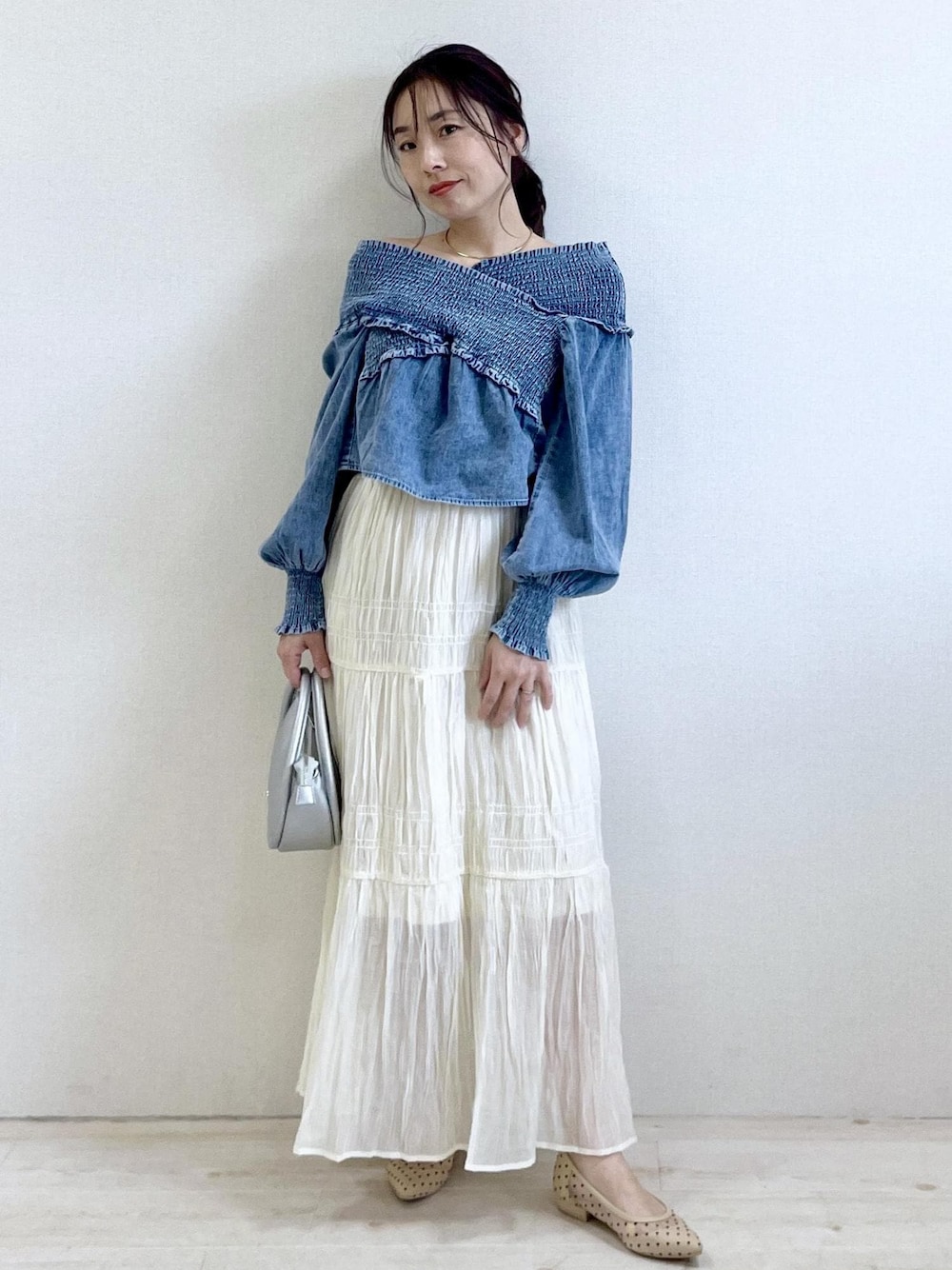 ブルー系のシャツ/ブラウス、ベージュ系のパンプス、シルバー系のショルダーバッグを着用したレディースの春コーディネートの1枚目の写真