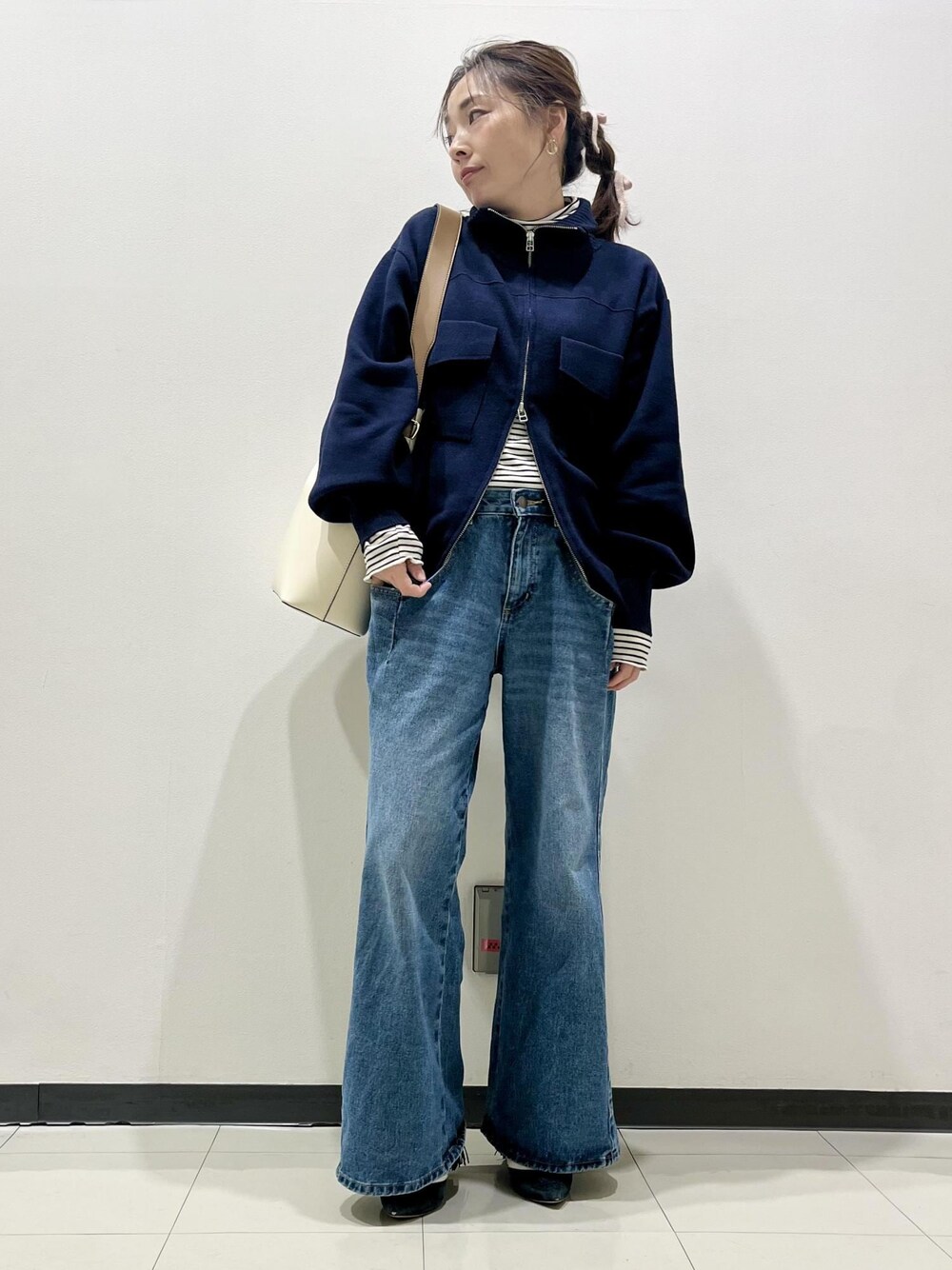 ホワイト系のニット/セーター、ブルー系のカーディガン/ボレロ、ブルー系のデニムパンツを着用したレディースの冬コーディネートの1枚目の写真