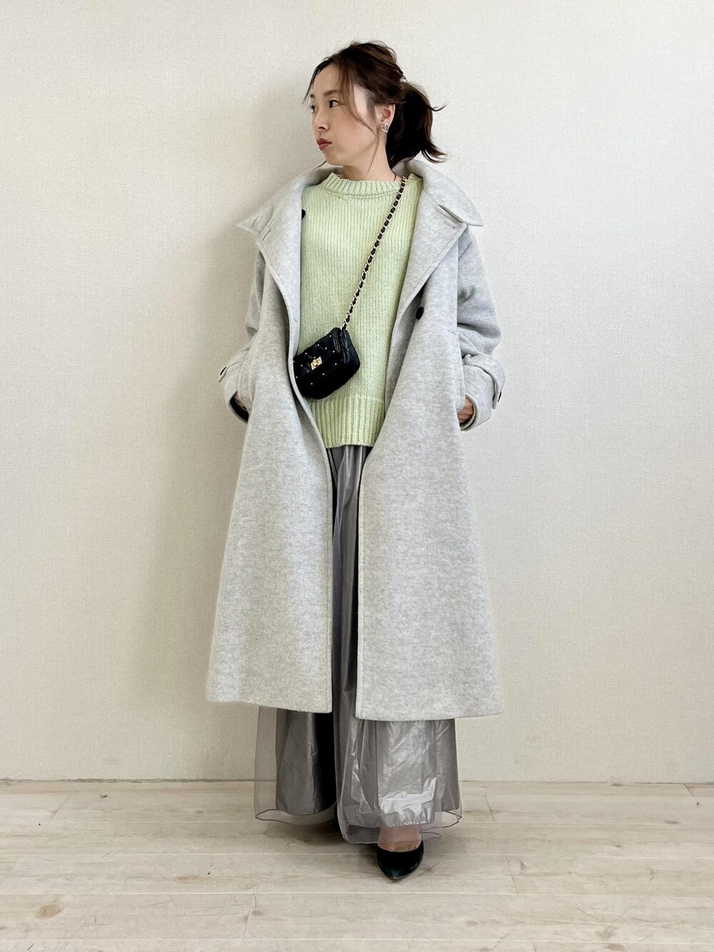 グレー系のその他アウター、グリーン系のニット/セーター、ブラック系のショルダーバッグを着用したレディースの冬コーディネートの1枚目の写真
