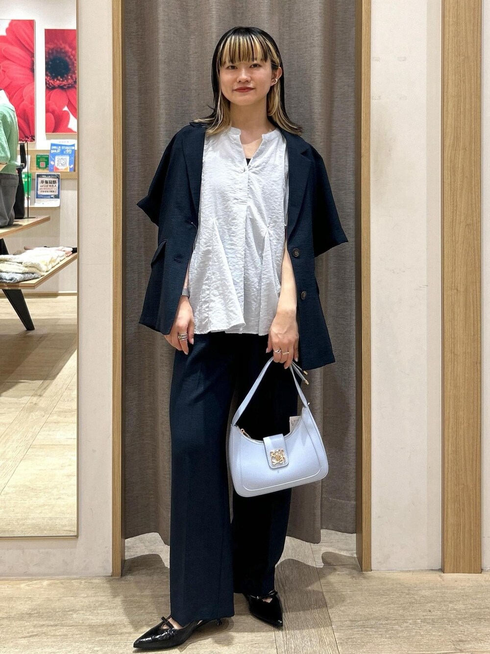ブルー系のハンドバッグ、ブラック系のパンプス、ブラック系のキャミソールを着用したレディースの夏コーディネートの1枚目の写真