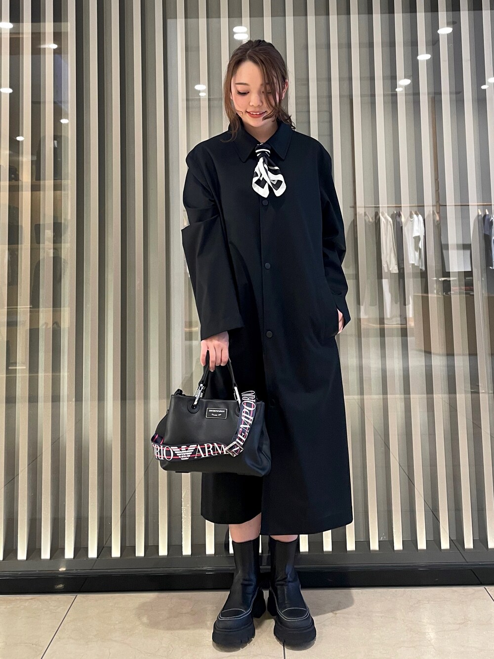 「EMPORIO ARMANI、エンポリオアルマーニ、モノトーン、モノトーンコーデ、メンズライク、メンズアイテム、スプリングコート、ブーツ、バッグ、レザー、スカーフ、ワンピース、白、黒、春のおしゃ見えテクニック」｜「EMPORIO ARMANIの【エンポリオ アルマーニ】MyEA ショッパー エコレザー製 スモール（ハンドバッグ、ブラック系）」を使った、airi naruseさん（レディース・157cm）の春コーディネートの1枚目の写真