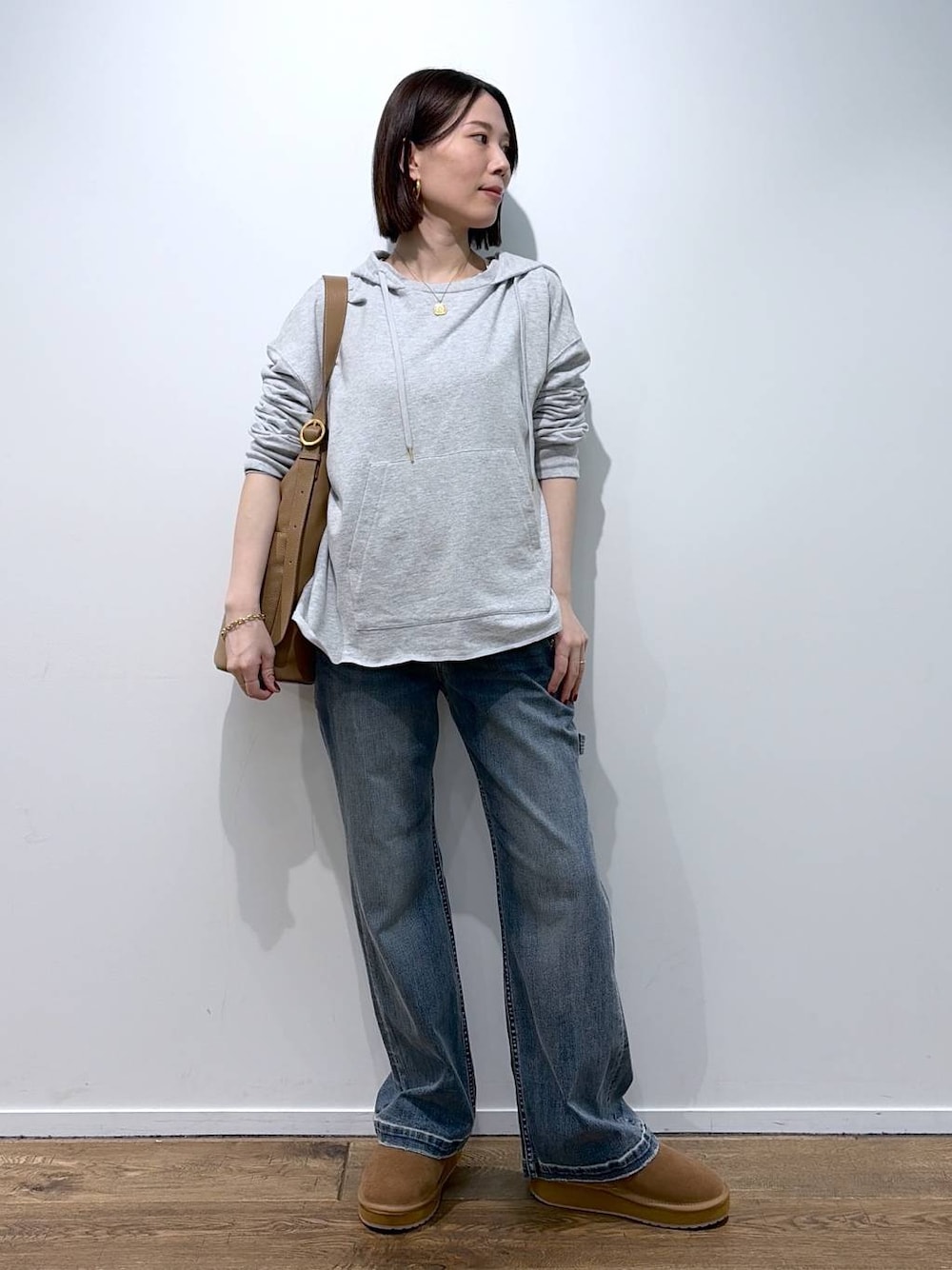 イエロー系のトートバッグ、イエロー系のその他シューズ、ブルー系のデニムパンツを着用したレディースの秋コーディネートの1枚目の写真