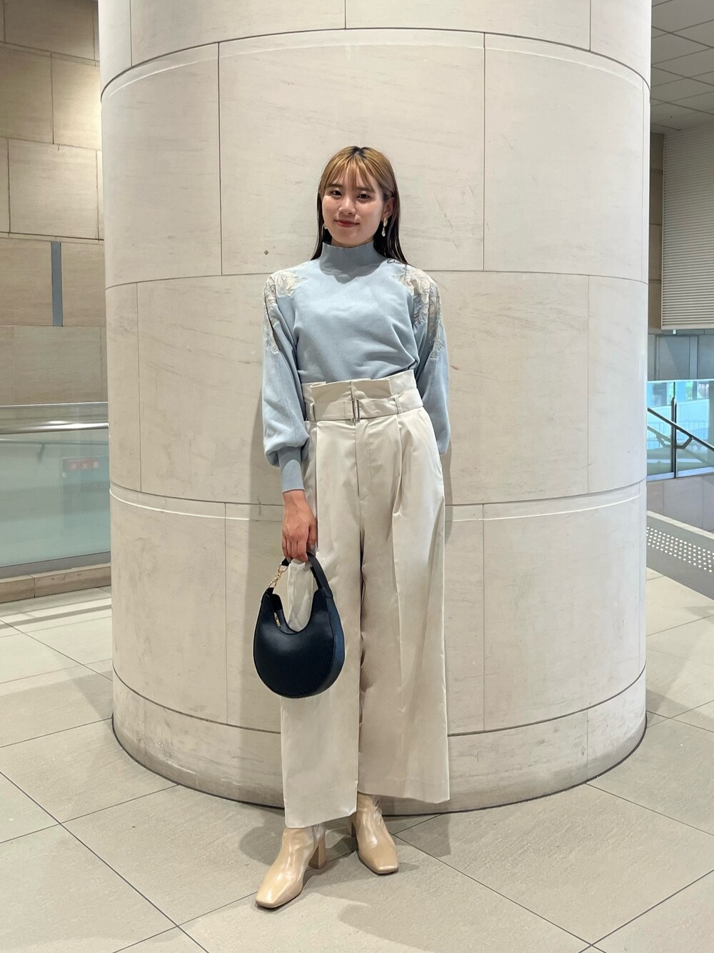 グリーン系のニット/セーター、ホワイト系のその他パンツ、ブラック系のハンドバッグを着用したレディースの秋コーディネートの1枚目の写真