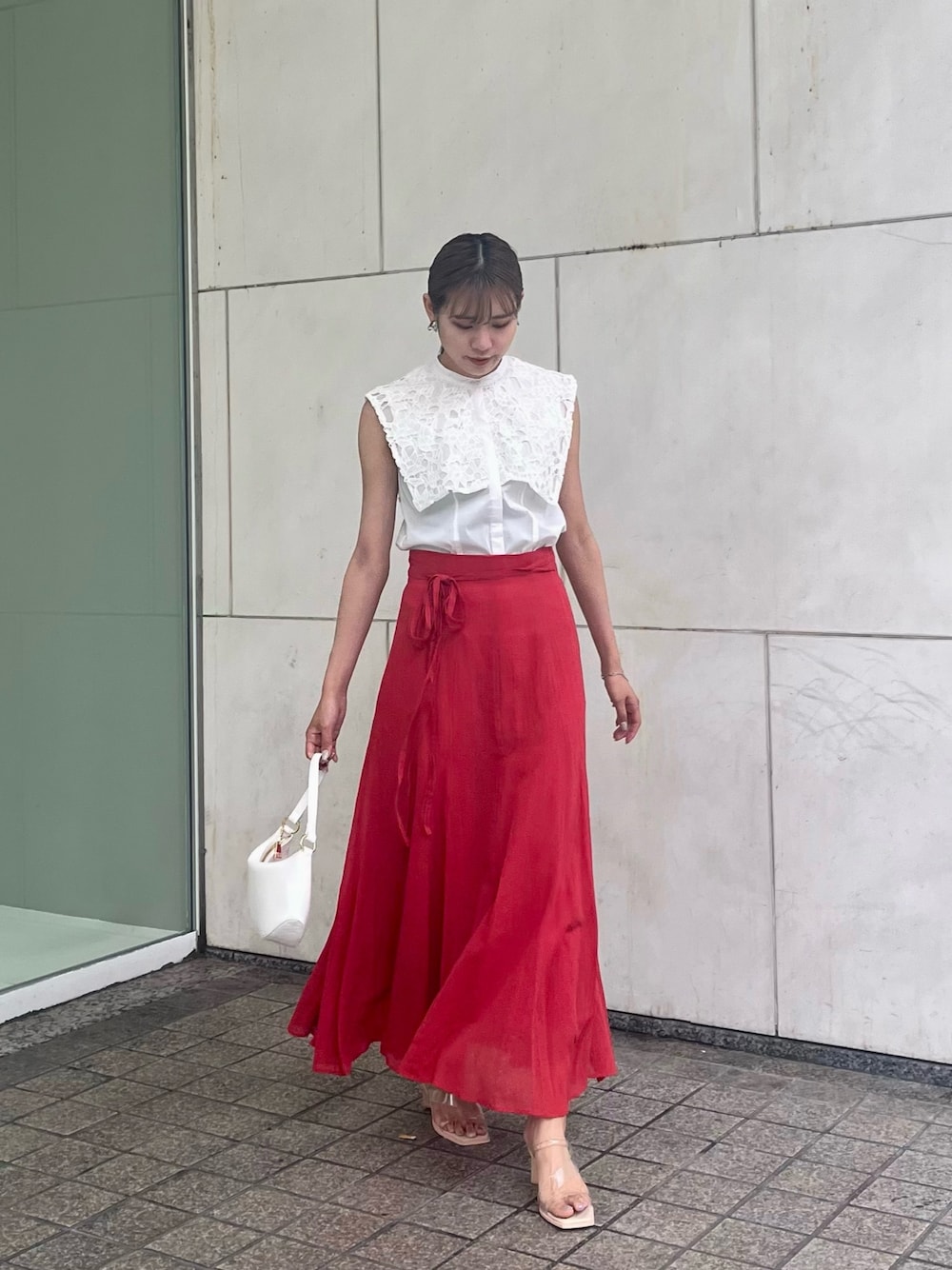 レッド系のスカート、ホワイト系のシャツ/ブラウスを着用したレディースの夏コーディネートの1枚目の写真