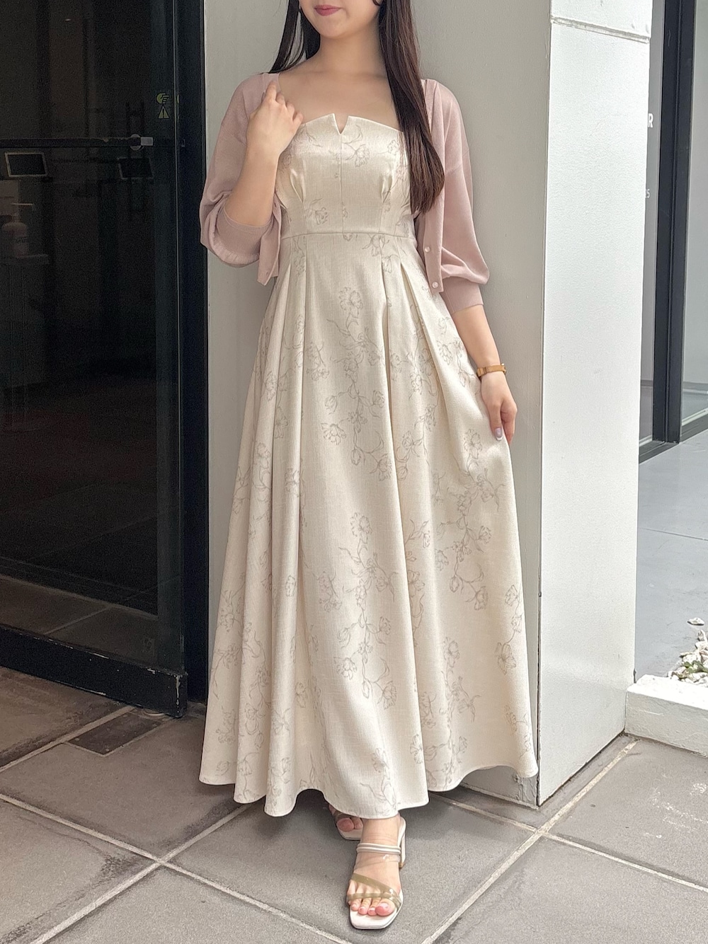 ホワイト系のワンピース、ホワイト系のサンダル、ベージュ系のカーディガン/ボレロを着用したレディースの夏コーディネートの1枚目の写真