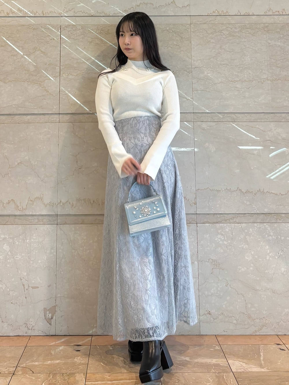 ブルー系のショルダーバッグ、ブラック系のブーツ、ブルー系のスカートを着用したレディースの冬コーディネートの1枚目の写真