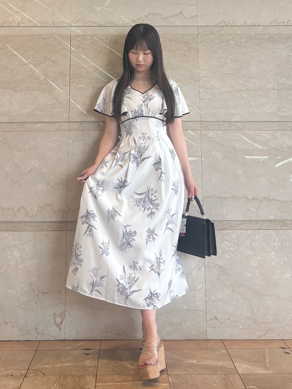 ホワイト系のワンピース、その他のサンダル、ブラック系のハンドバッグを着用したレディースの夏コーディネートの1枚目の写真