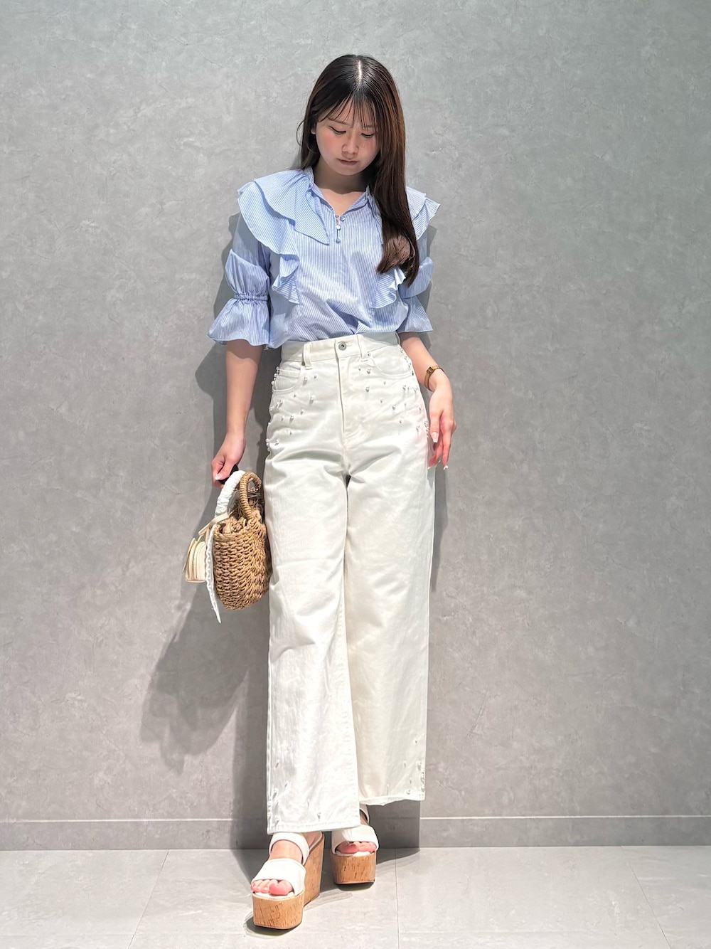 ホワイト系のデニムパンツ、ブルー系のシャツ/ブラウス、ベージュ系のハンドバッグを着用したレディースの春コーディネートの1枚目の写真