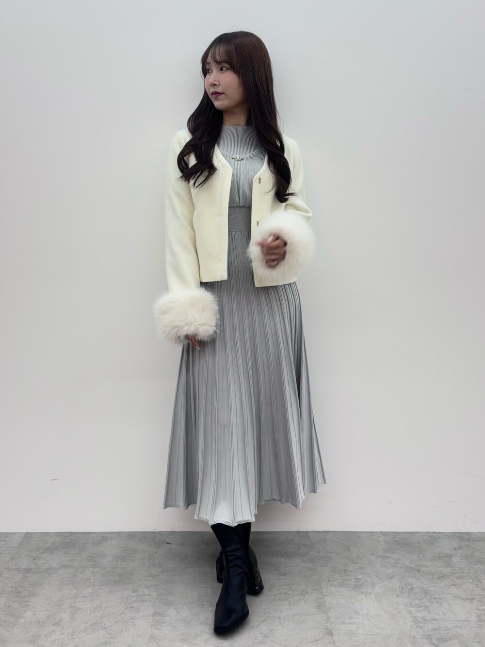 ブラック系のブーツ、ホワイト系のその他アウター、グレー系のワンピースを着用したレディースの冬コーディネートの1枚目の写真