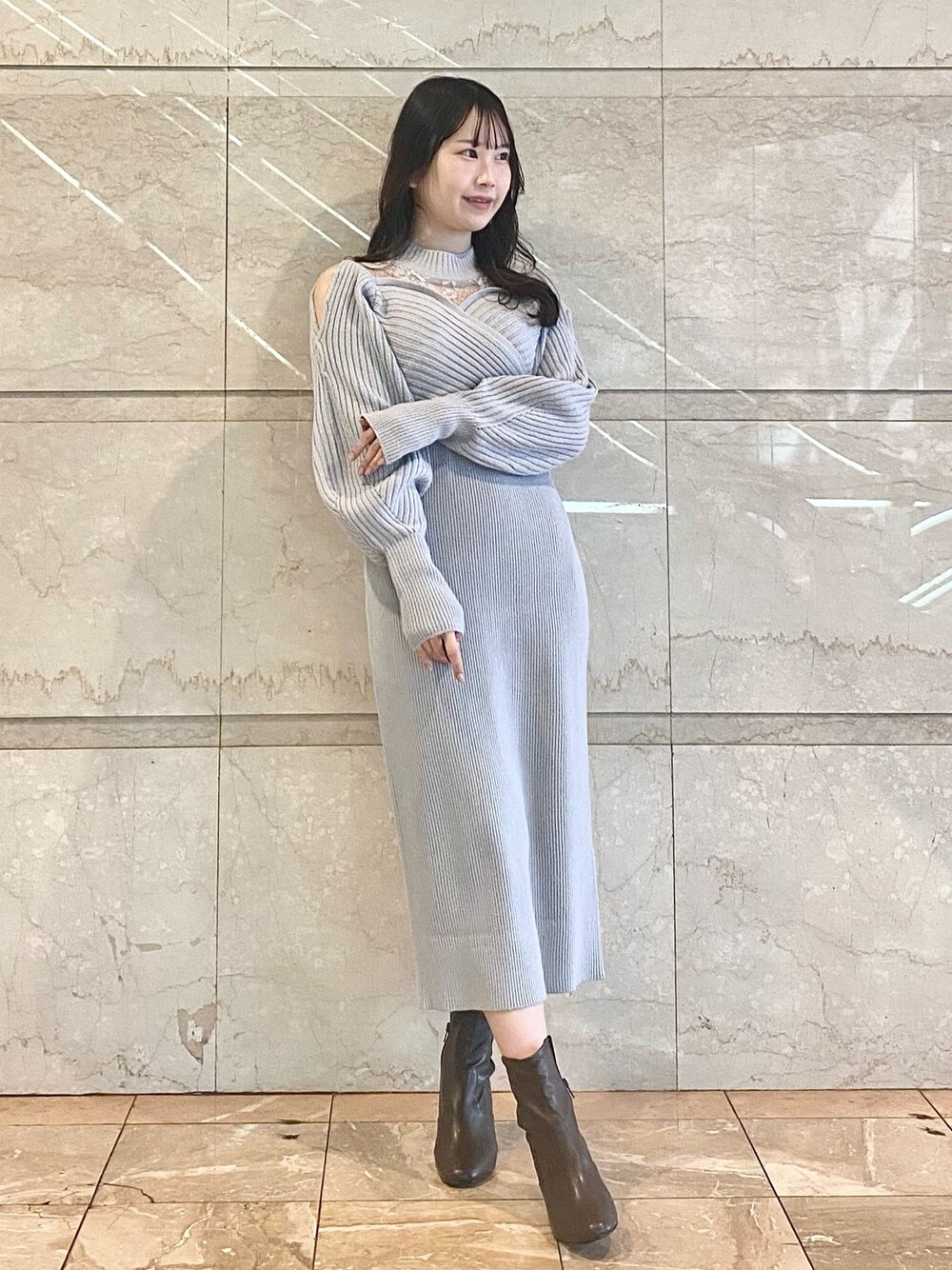 グレー系のワンピース、ブラウン系のブーツを着用したレディースの冬コーディネートの1枚目の写真