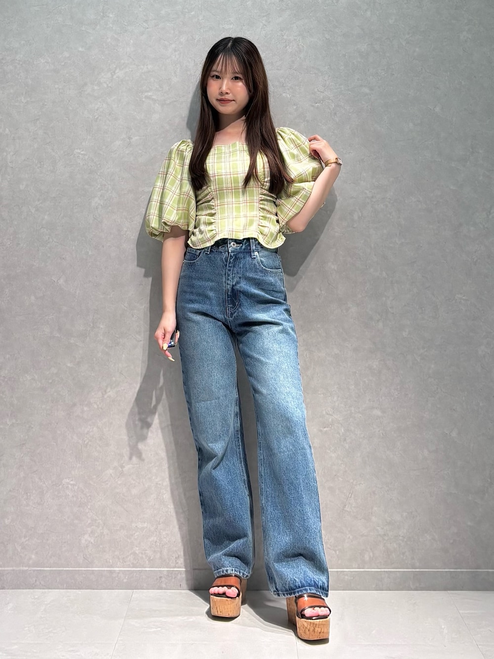 ブルー系のデニムパンツ、ブラウン系のサンダル、グリーン系のシャツ/ブラウスを着用したレディースの春コーディネートの1枚目の写真
