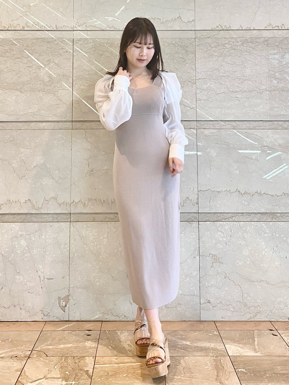 ベージュ系のワンピース、ブラウン系のサンダルを着用したレディースの春コーディネートの1枚目の写真