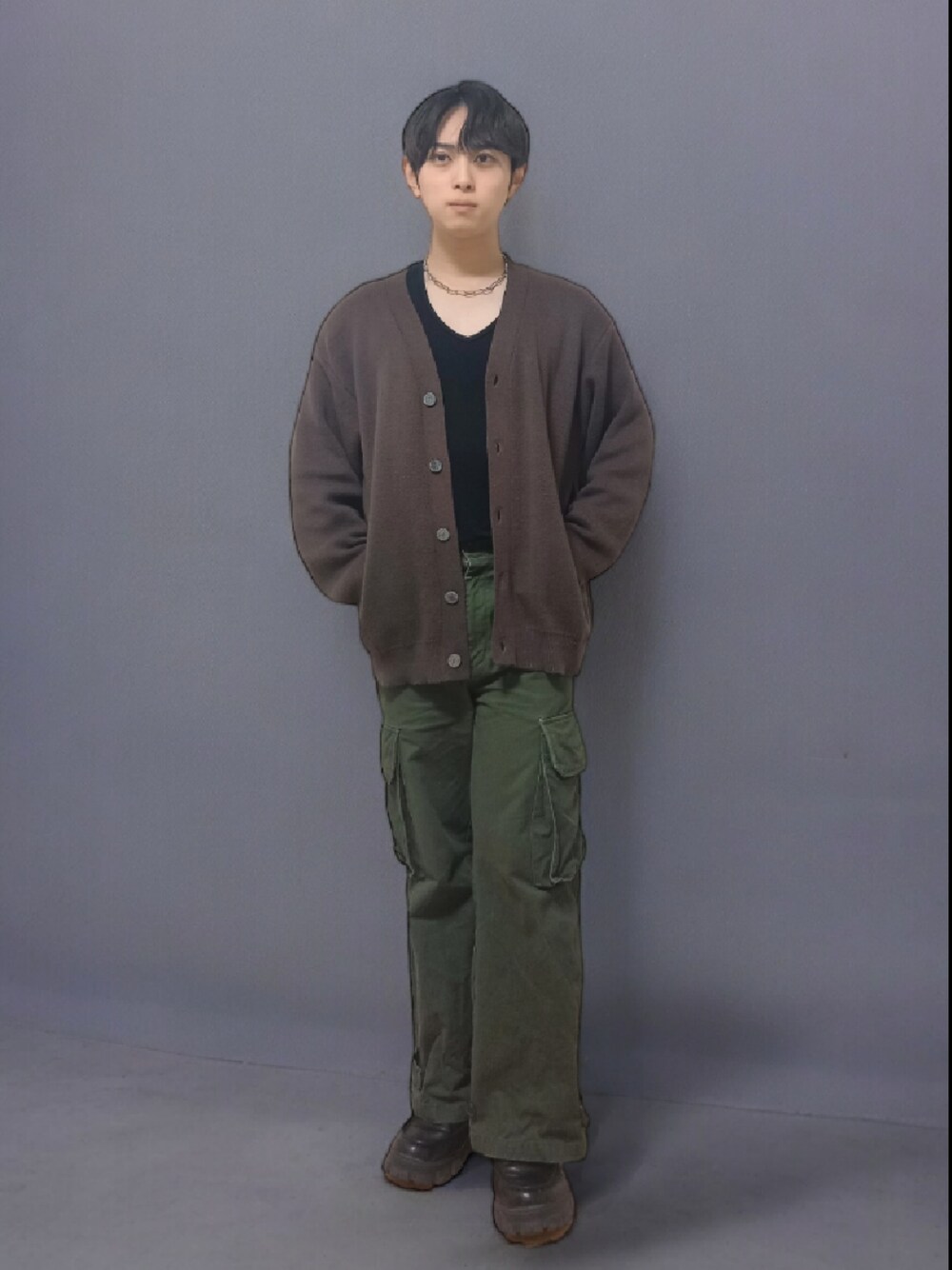 ブラウン系のカーディガン/ボレロ、グリーン系のカーゴパンツ、ブラック系のローファーを着用したメンズの春コーディネートの1枚目の写真