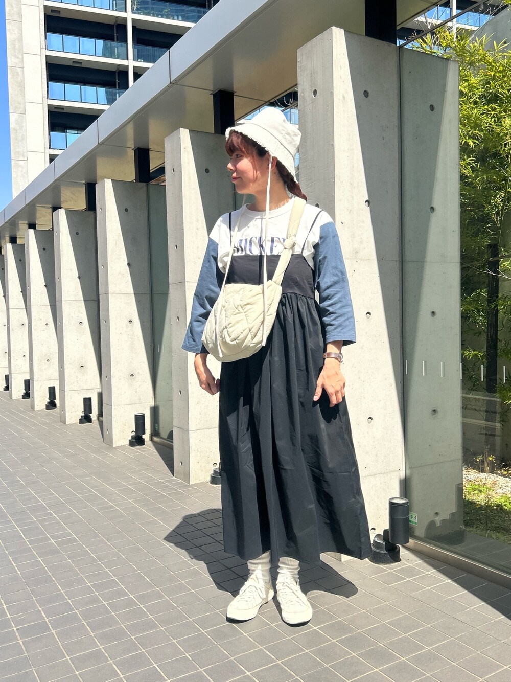 ホワイト系のショルダーバッグ、ホワイト系のTシャツ/カットソー、ブラック系のワンピースを着用したレディースの春コーディネートの1枚目の写真