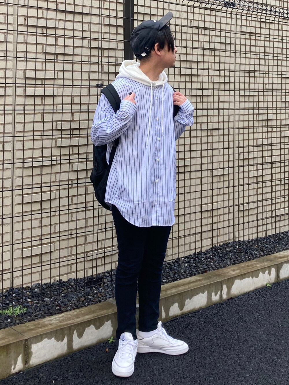 ブラック系のデニムパンツ、ブルー系のシャツ/ブラウス、ホワイト系のスニーカーを着用したメンズの春コーディネートの1枚目の写真