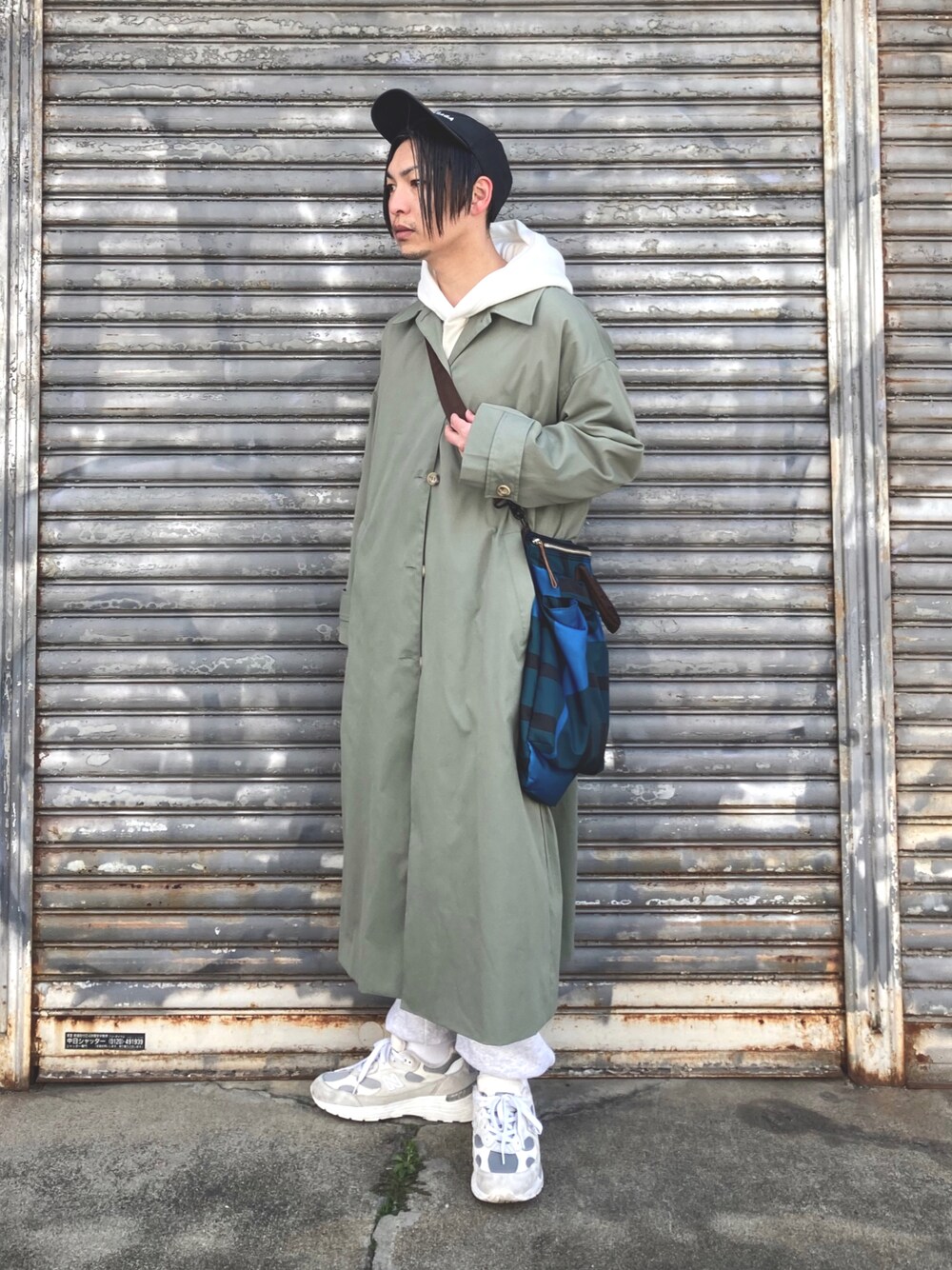 「スウェットパンツ、春コーデ、春アウター、レイヤードスタイル、シンプルコーデ、New Balance、キャップ、トートバッグ、厚底シューズ、プチプラ、パーカー、スニーカー、オーバーサイズ、ビッグシルエット、カジュアルコーデ」｜「Lullの【Lull / ルル】2wayステンカラーロングコート（ステンカラーコート、グリーン系）」を使った、 松波 侑亮さん（メンズ・164cm）の冬コーディネートの1枚目の写真