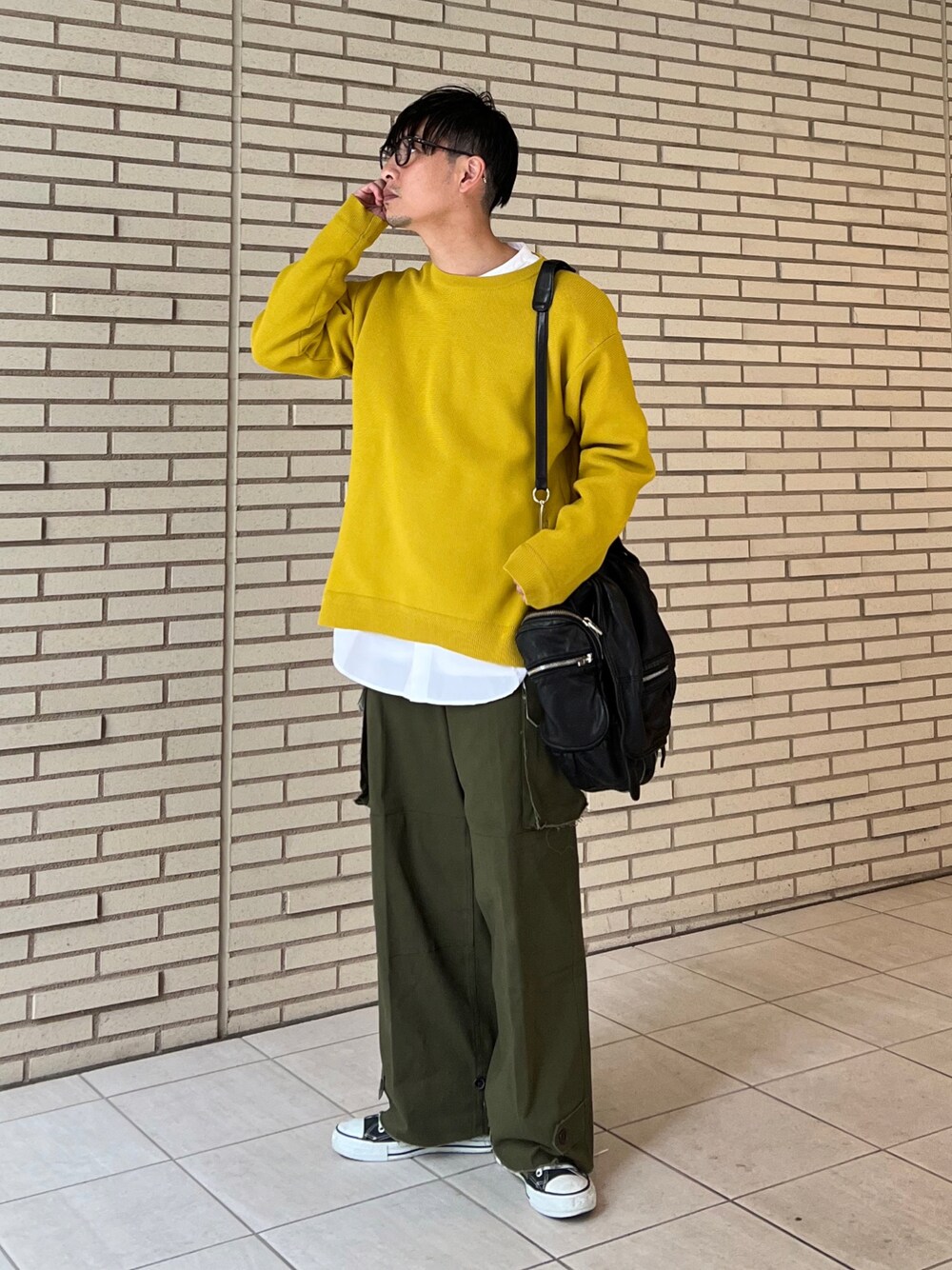 オレンジ系のニット/セーター、ホワイト系のシャツ/ブラウス、グリーン系のカーゴパンツを着用したメンズの冬コーディネートの1枚目の写真
