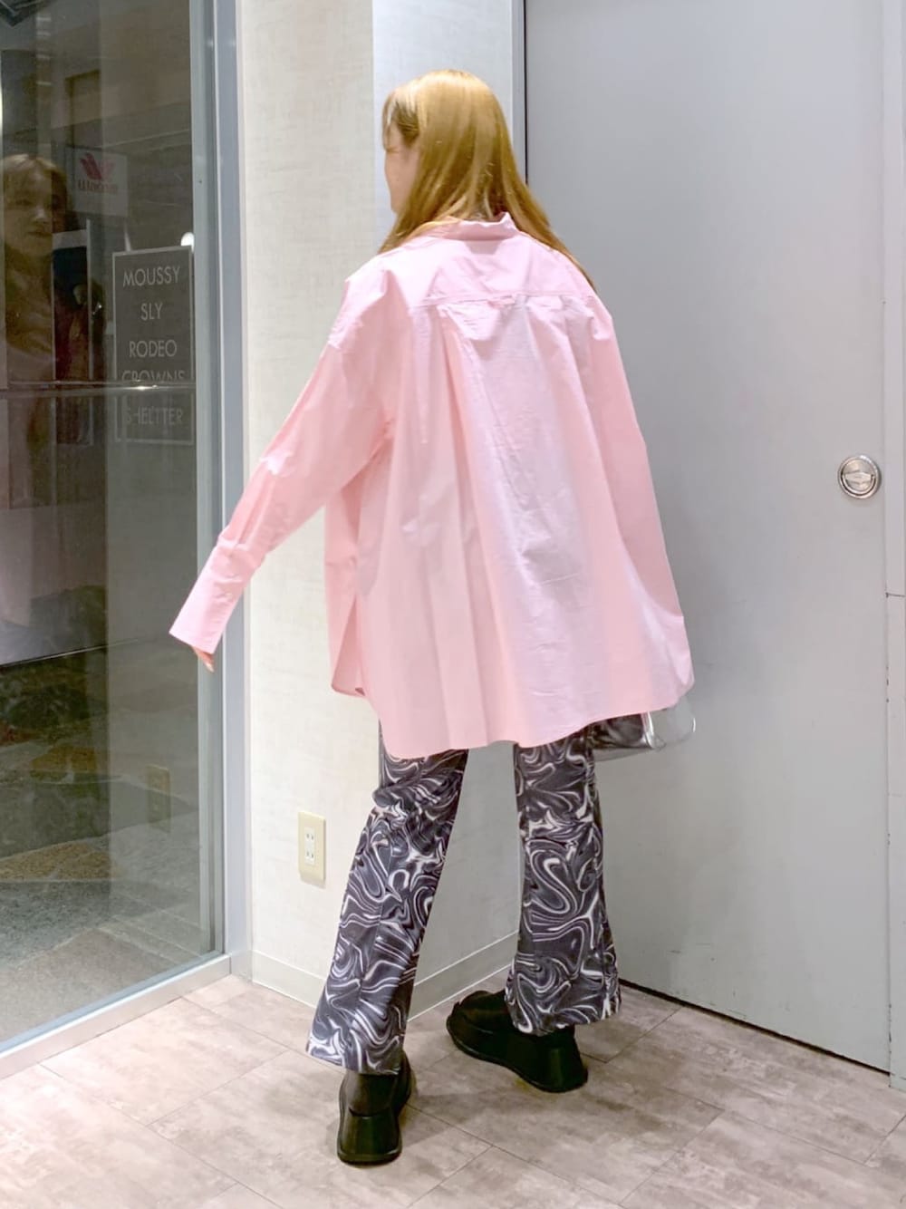 ピンク系のシャツ/ブラウス、ブラック系のパンツ、ブラック系のスリッポンを着用したレディースの春コーディネートの2枚目の写真