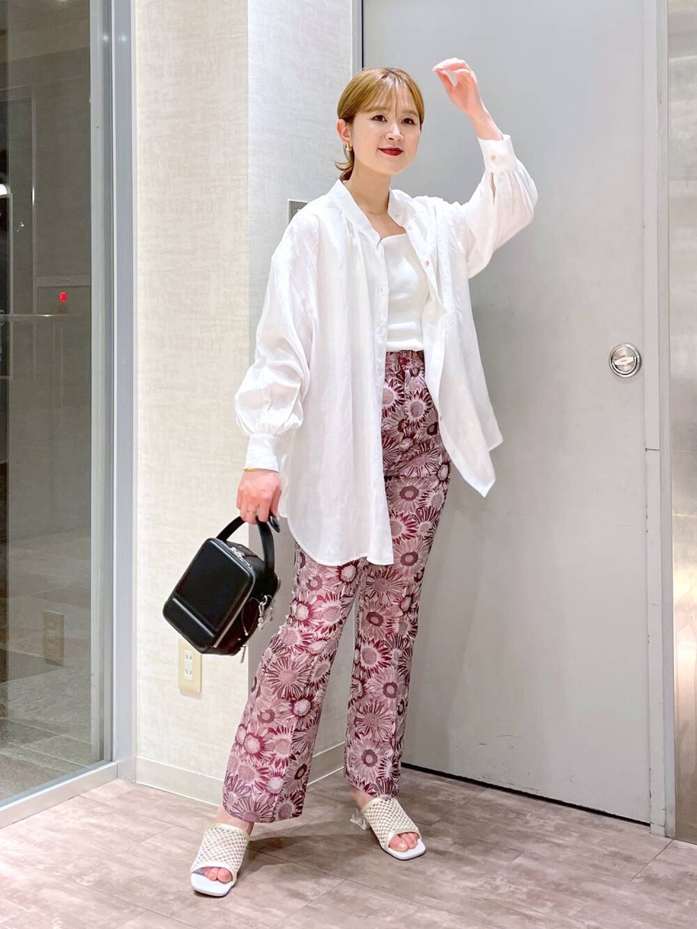 ピンク系のパンツ、ホワイト系のシャツ/ブラウス、ホワイト系のニット/セーターを着用したレディースの春コーディネートの2枚目の写真