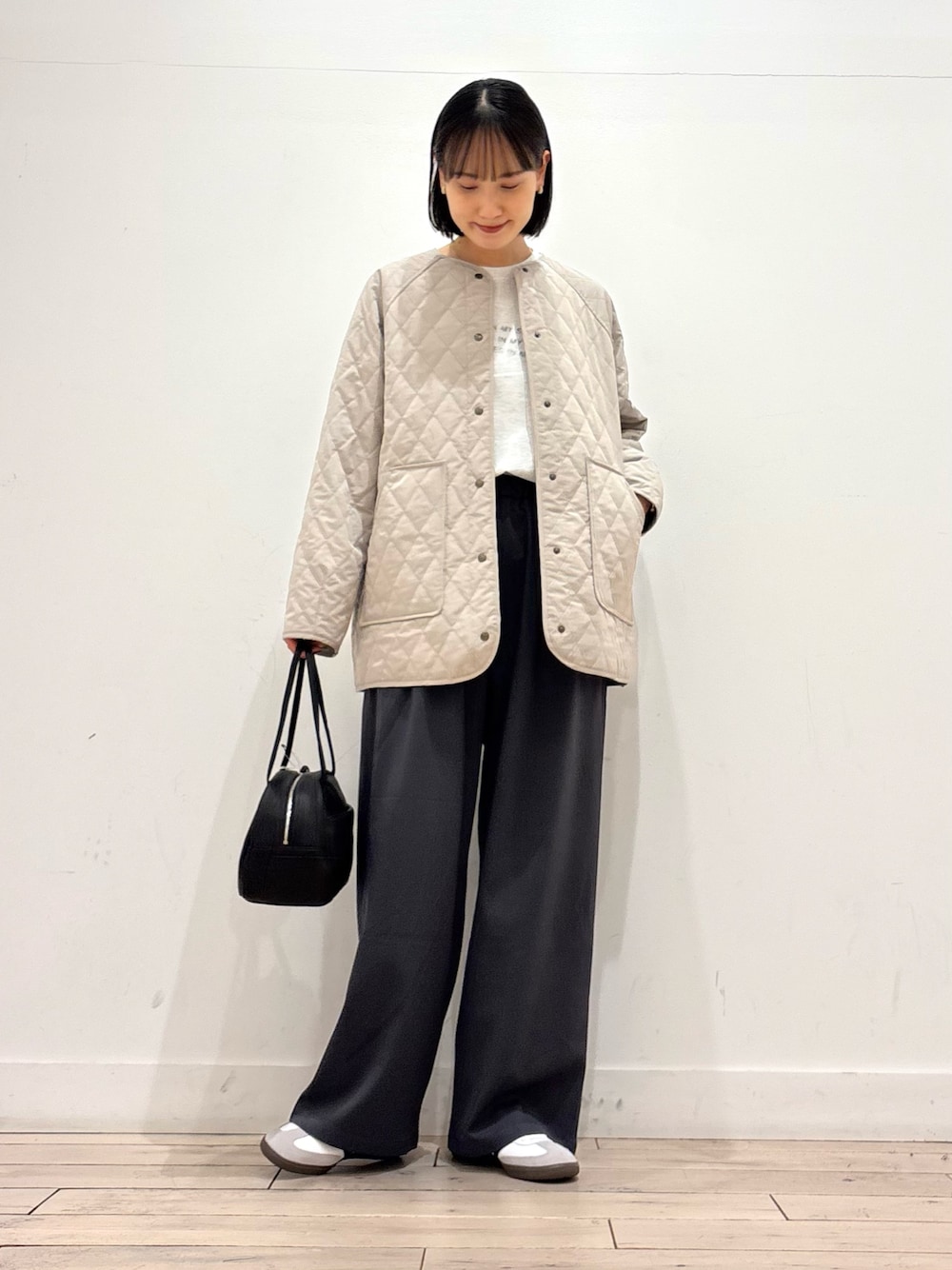 グレー系のその他パンツ、ホワイト系のスニーカー、ブラック系のボストンバッグを着用したレディースの冬コーディネートの1枚目の写真