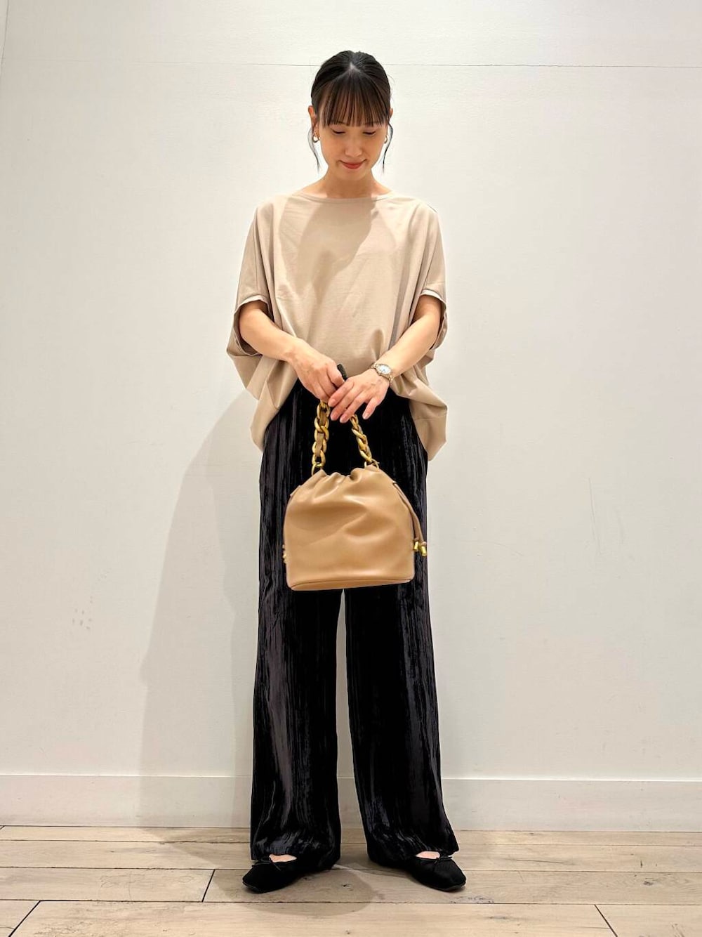 ブラウン系のショルダーバッグ、ブラック系のバレエシューズ、ベージュ系のTシャツ/カットソーを着用したレディースの夏コーディネートの1枚目の写真