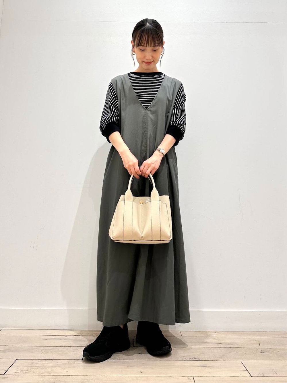 ホワイト系のトートバッグ、ブラック系のスニーカー、ブラック系のTシャツ/カットソーを着用したレディースの夏コーディネートの1枚目の写真