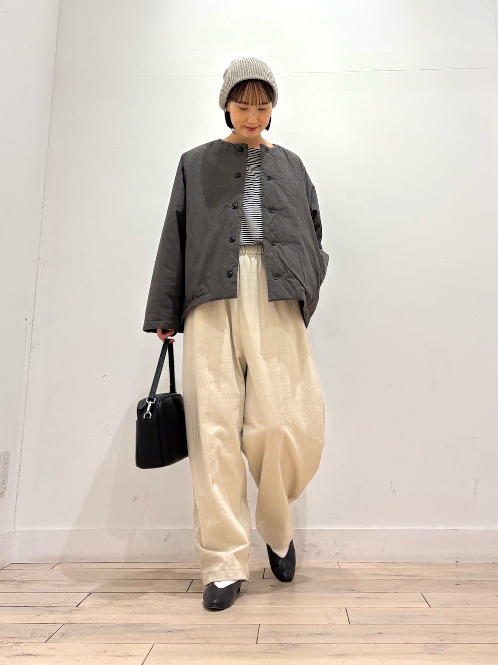 グレー系のダウンジャケット/コート、ブラック系のTシャツ/カットソー、ホワイト系のその他パンツを着用したレディースの秋コーディネートの1枚目の写真