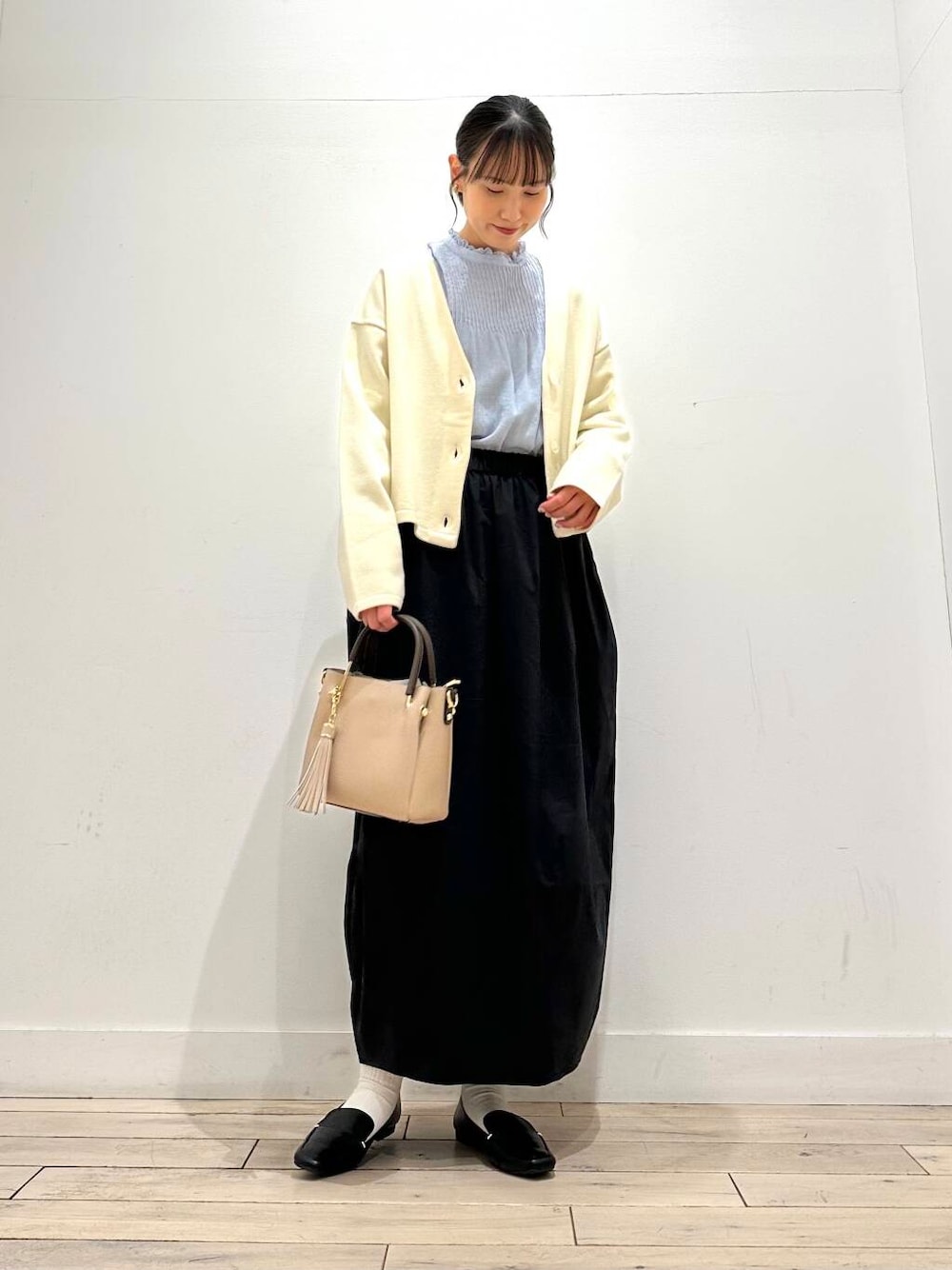 ブラック系のローファー、ベージュ系のトートバッグ、ブルー系のシャツ/ブラウスを着用したレディースの冬コーディネートの1枚目の写真