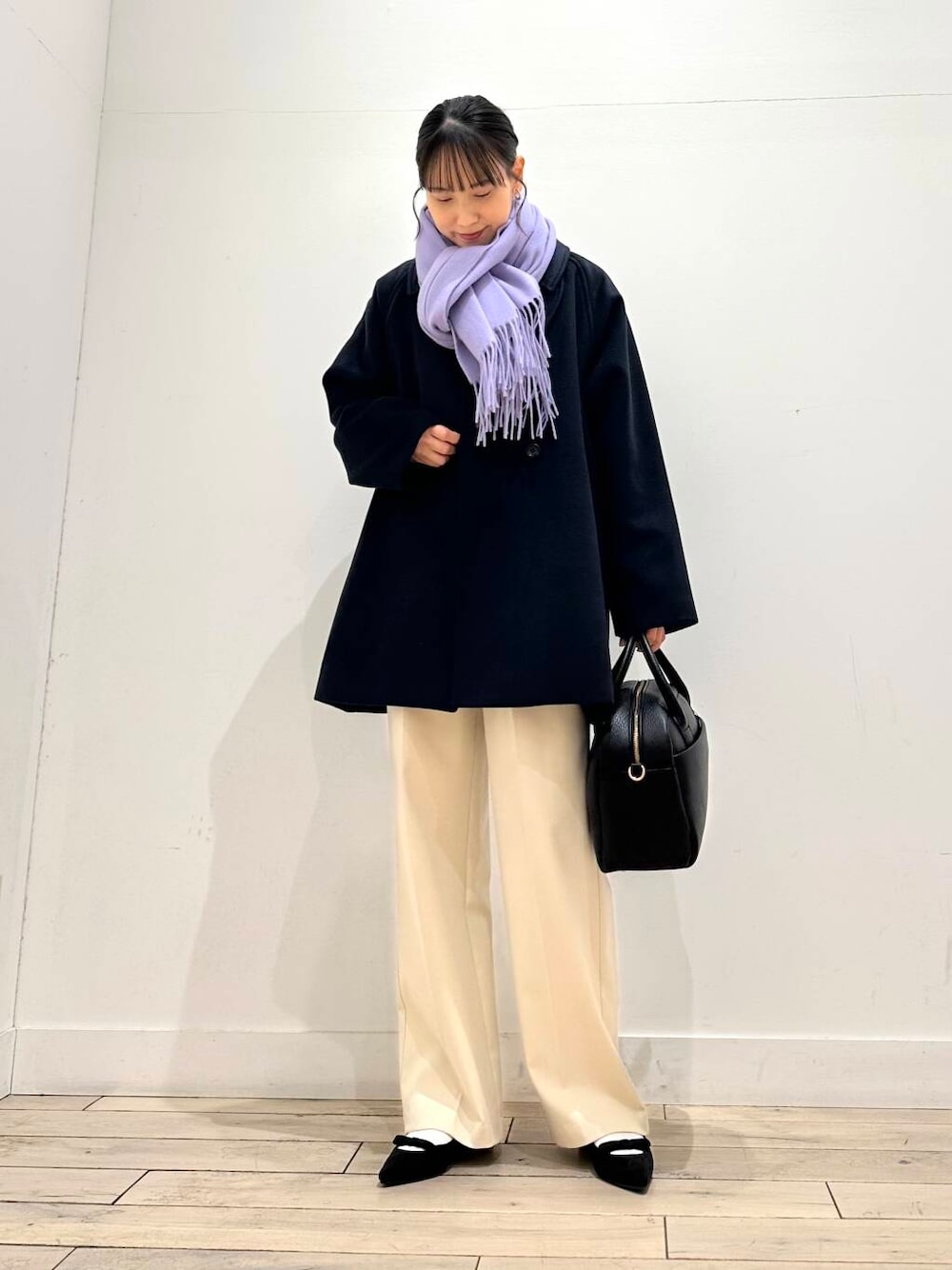 ブラック系のボストンバッグ、ブラック系のパンプス、ブルー系のステンカラーコートを着用したレディースの冬コーディネートの1枚目の写真