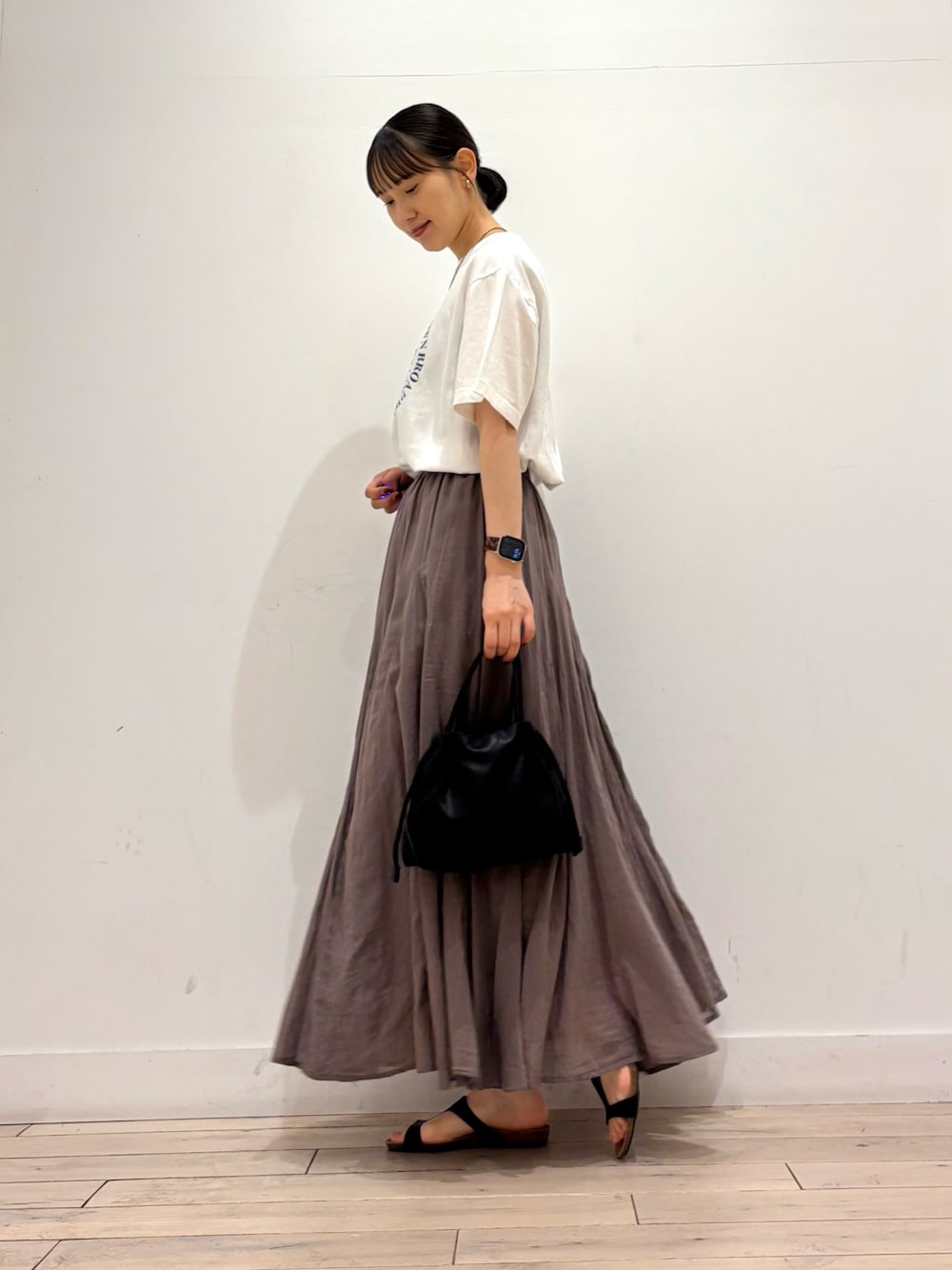 ホワイト系のTシャツ/カットソー、グレー系のスカート、ブラック系のショルダーバッグを着用したレディースの夏コーディネートの1枚目の写真