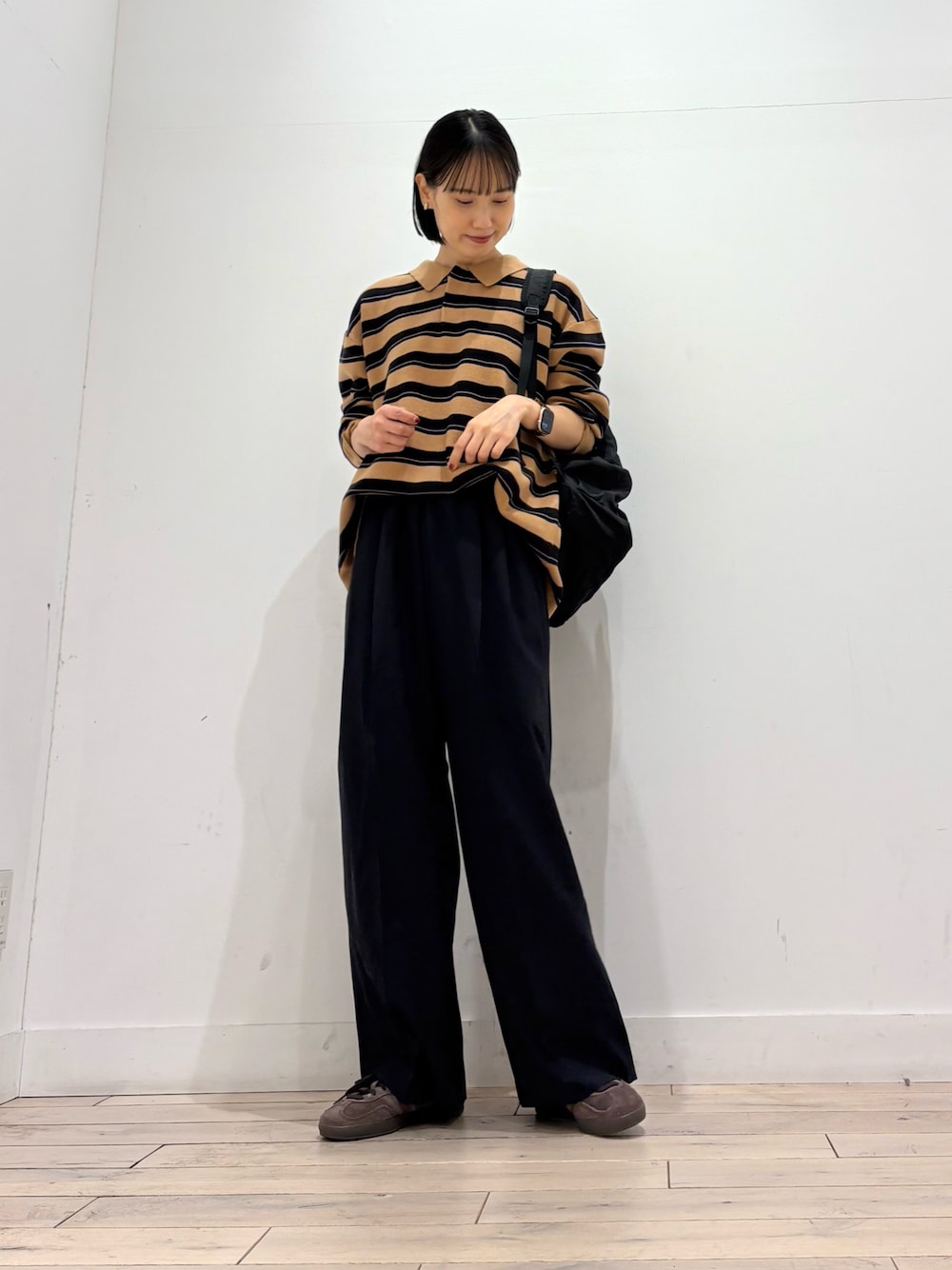 ブラウン系のニット/セーター、ブルー系のその他パンツ、ブラウン系のスニーカーを着用したレディースの秋コーディネートの1枚目の写真