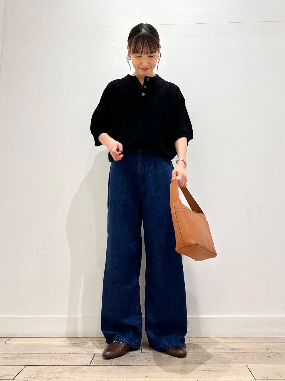 ブラウン系のローファー、イエロー系のショルダーバッグ、ブラック系のニット/セーターを着用したレディースの夏コーディネートの1枚目の写真