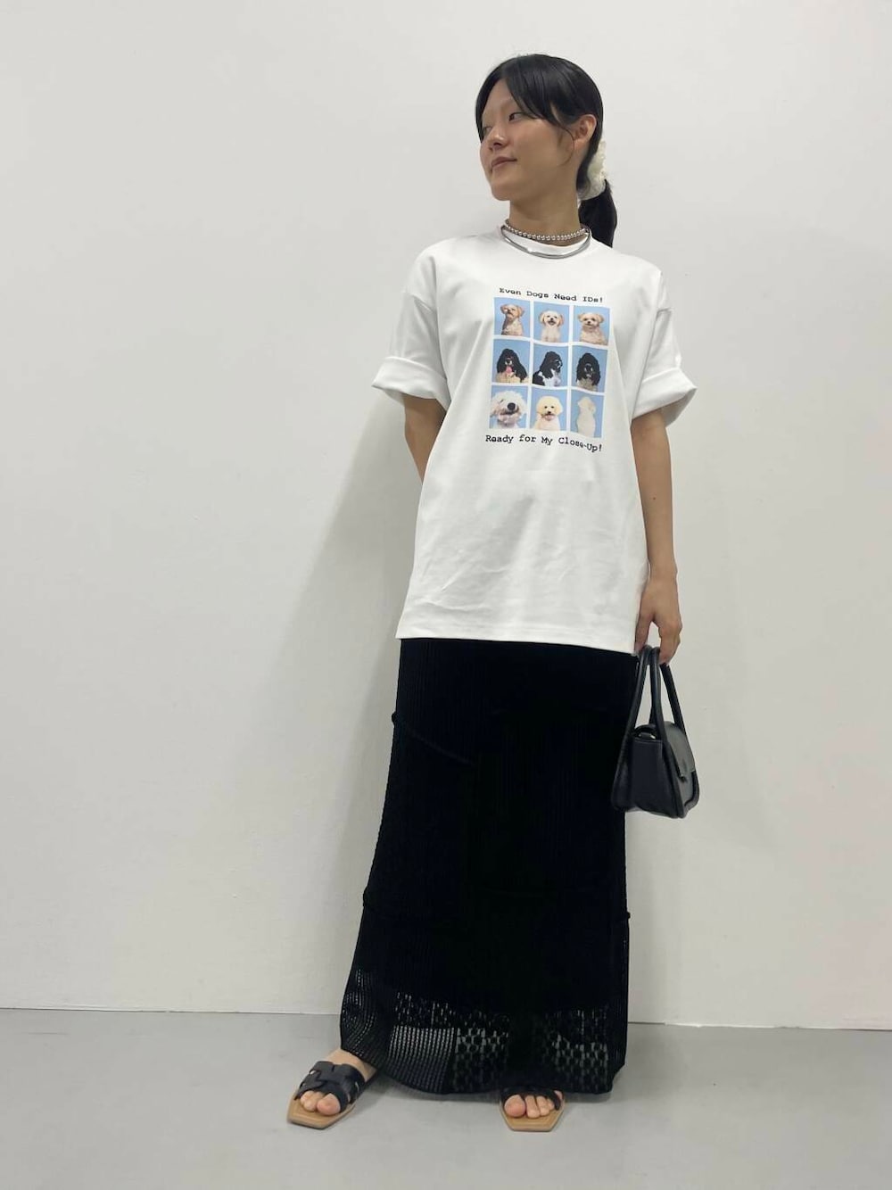 ブラック系のスカート、ホワイト系のTシャツ/カットソー、シルバー系のネックレスを着用したレディースの夏コーディネートの1枚目の写真
