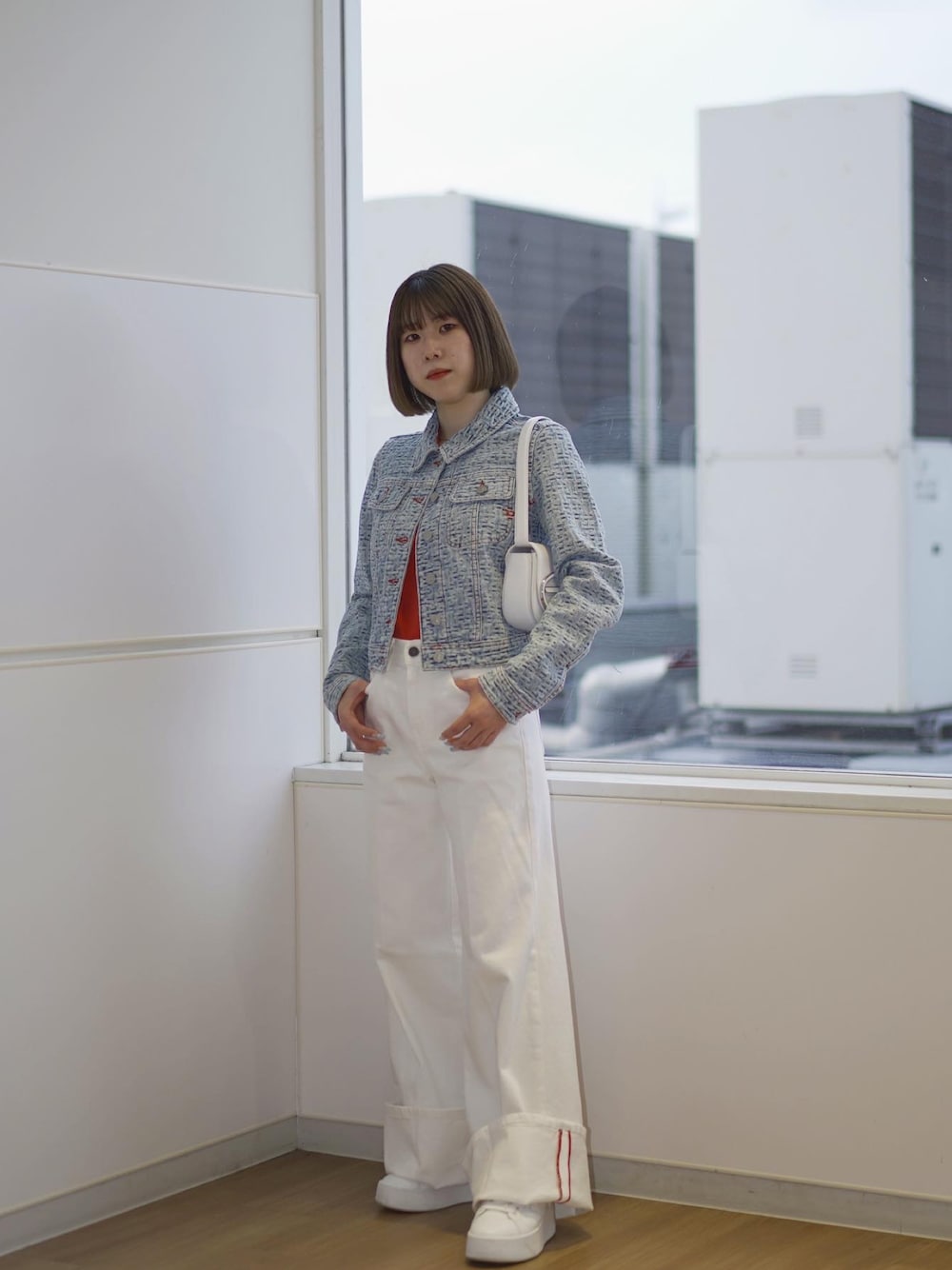 ブルー系のデニムジャケット、ホワイト系のショルダーバッグ、レッド系のTシャツ/カットソーを着用したレディースの春コーディネートの1枚目の写真