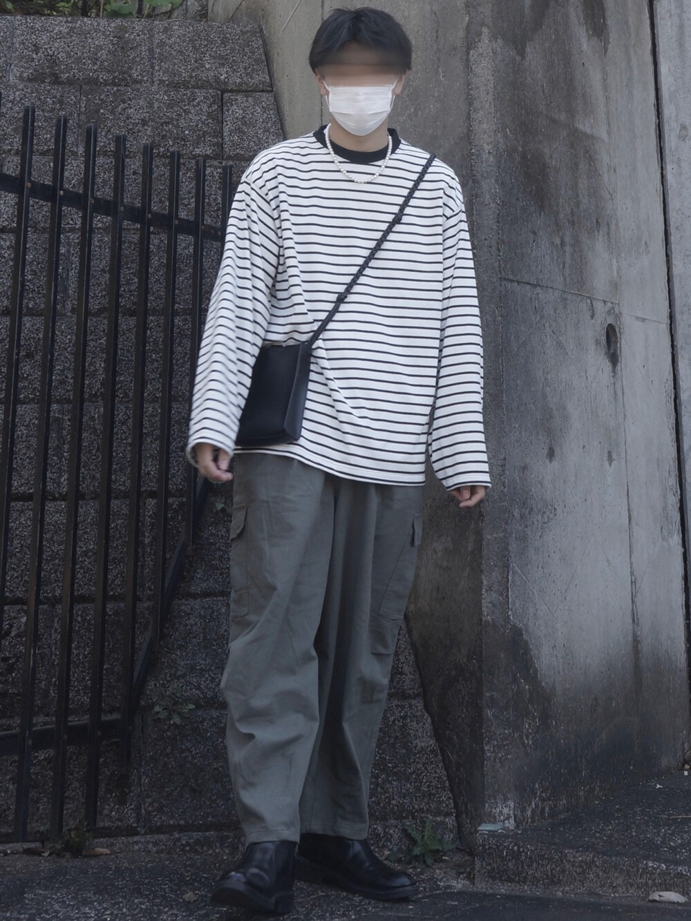 ホワイト系のTシャツ/カットソー、ベージュ系のその他パンツ、ブラック系のショルダーバッグを着用したメンズの春コーディネートの1枚目の写真