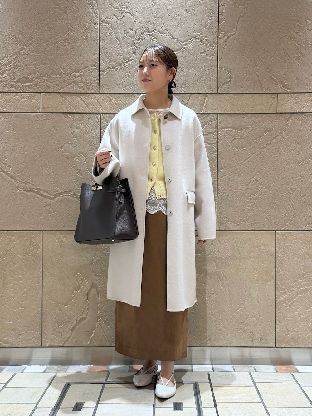 イエロー系のカーディガン/ボレロ、ホワイト系のシャツ/ブラウス、イエロー系のスカートを着用したレディースの秋コーディネートの1枚目の写真