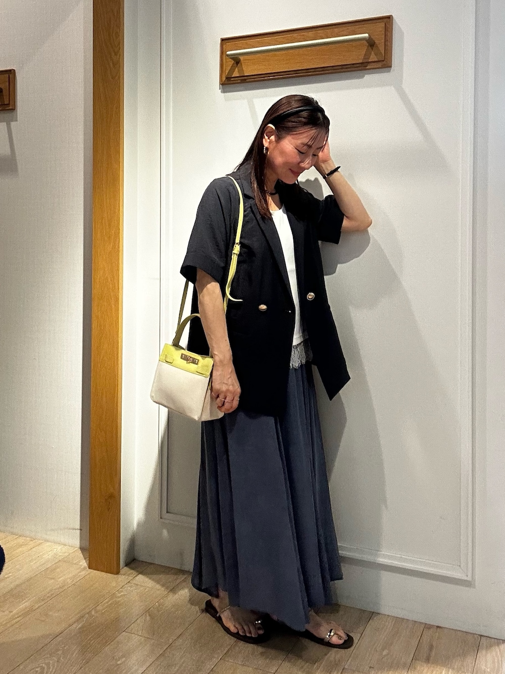 グレー系のテーラードジャケット、ホワイト系のTシャツ/カットソー、ブルー系のスカートを着用したレディースの夏コーディネートの1枚目の写真