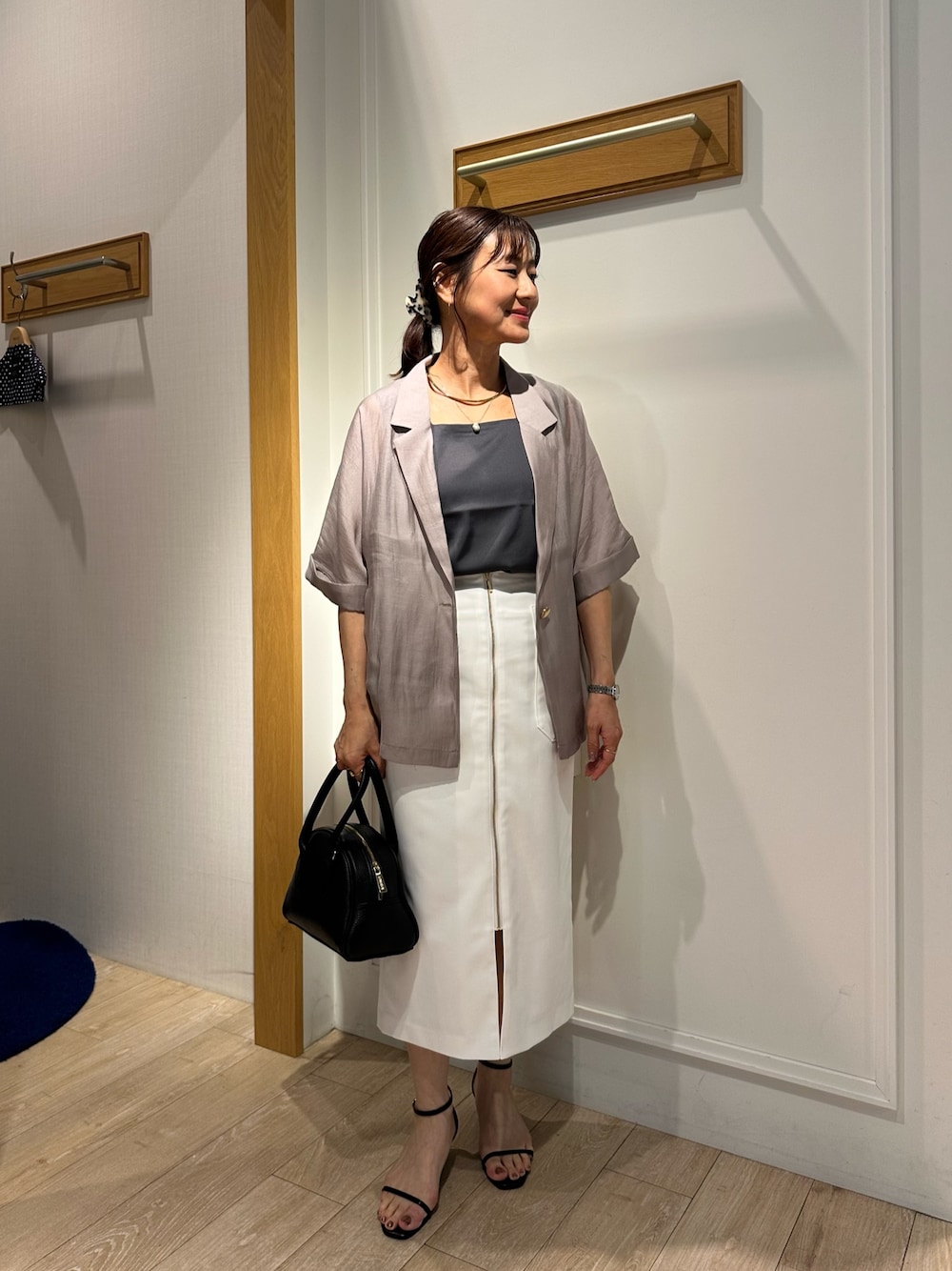 ブラック系のサンダル、グレー系のTシャツ/カットソー、ホワイト系のスカートを着用したレディースの夏コーディネートの1枚目の写真