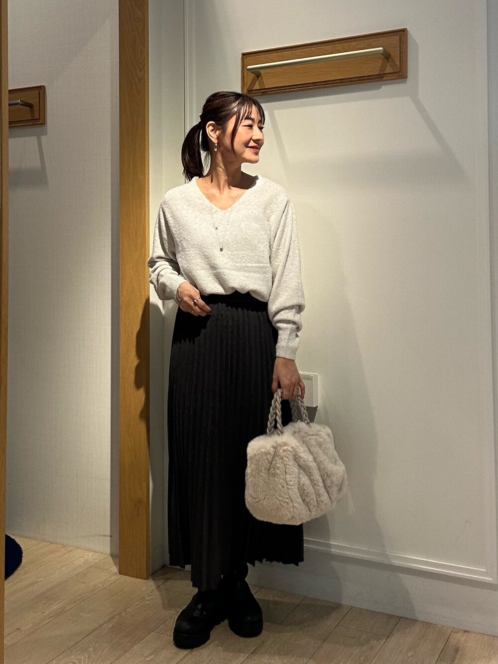ホワイト系のニット/セーター、グレー系のスカート、ホワイト系のトートバッグを着用したレディースの秋コーディネートの1枚目の写真