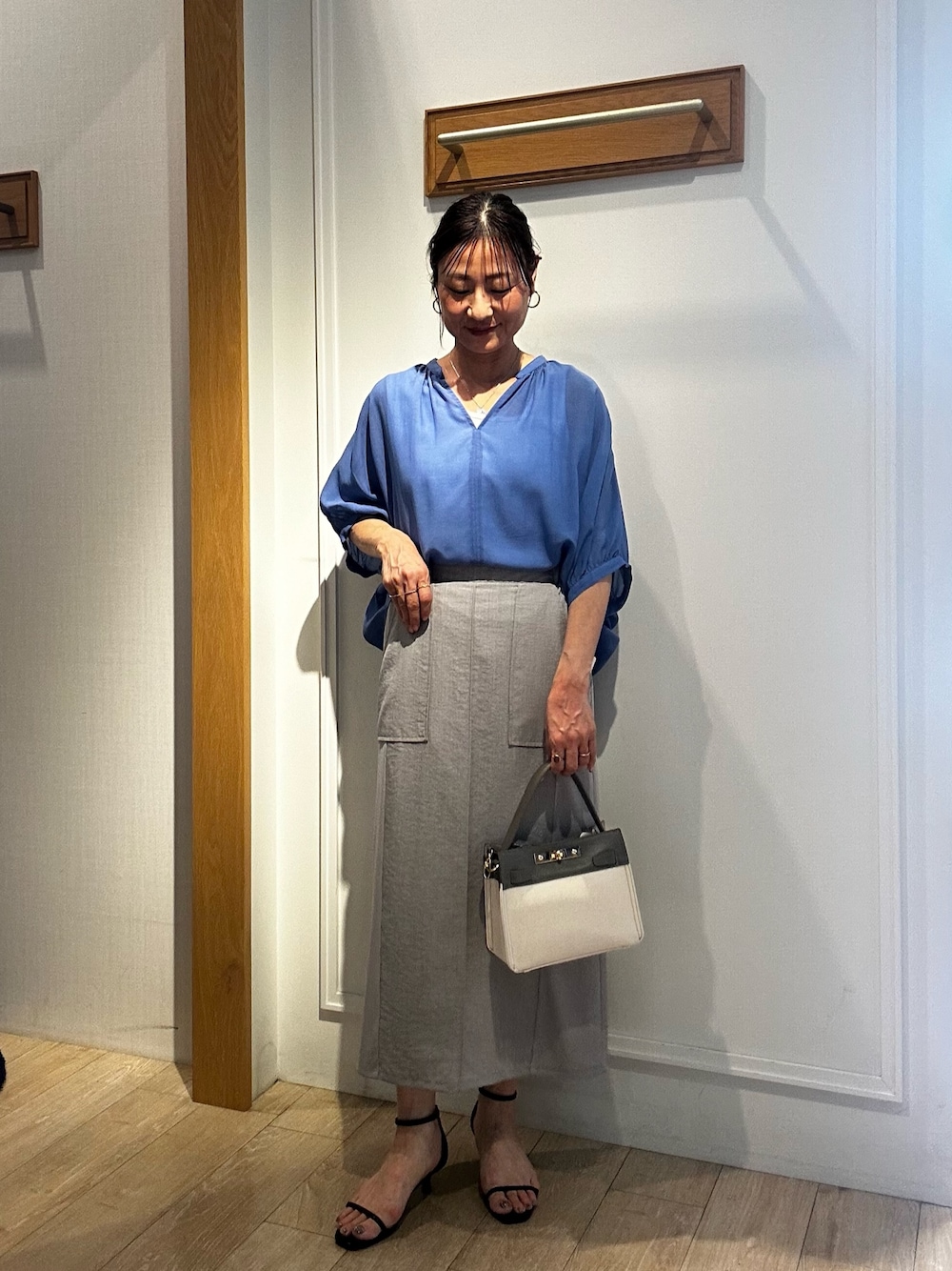 ブルー系のシャツ/ブラウス、ホワイト系のTシャツ/カットソー、グレー系のスカートを着用したレディースの夏コーディネートの1枚目の写真
