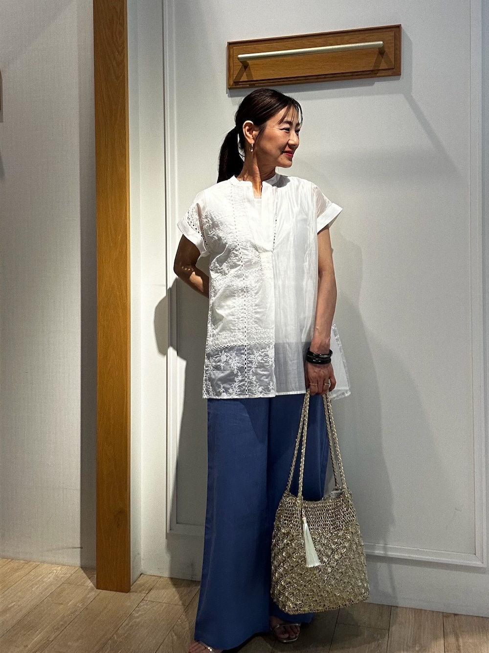 ホワイト系のシャツ/ブラウス、ホワイト系のTシャツ/カットソー、ゴールド系のトートバッグを着用したレディースの夏コーディネートの1枚目の写真