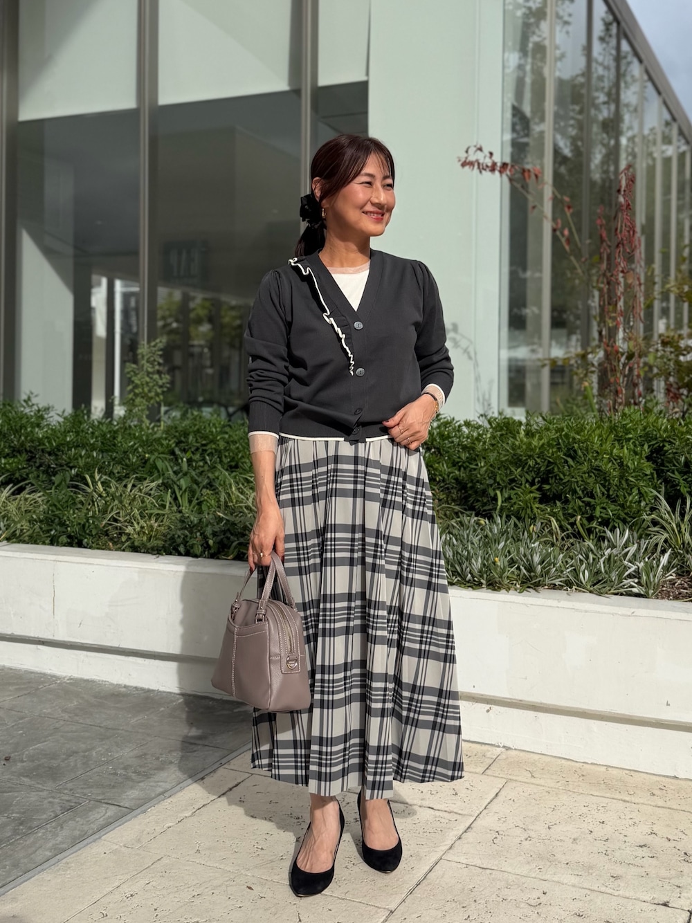 グレー系のカーディガン/ボレロ、ホワイト系のTシャツ/カットソー、ホワイト系のスカートを着用したレディースの秋コーディネートの1枚目の写真