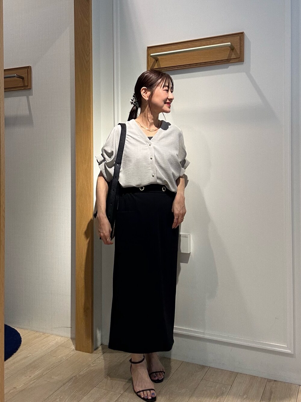 ベージュ系のシャツ/ブラウス、ブラック系のスカート、ブラック系のサンダルを着用したレディースの夏コーディネートの1枚目の写真