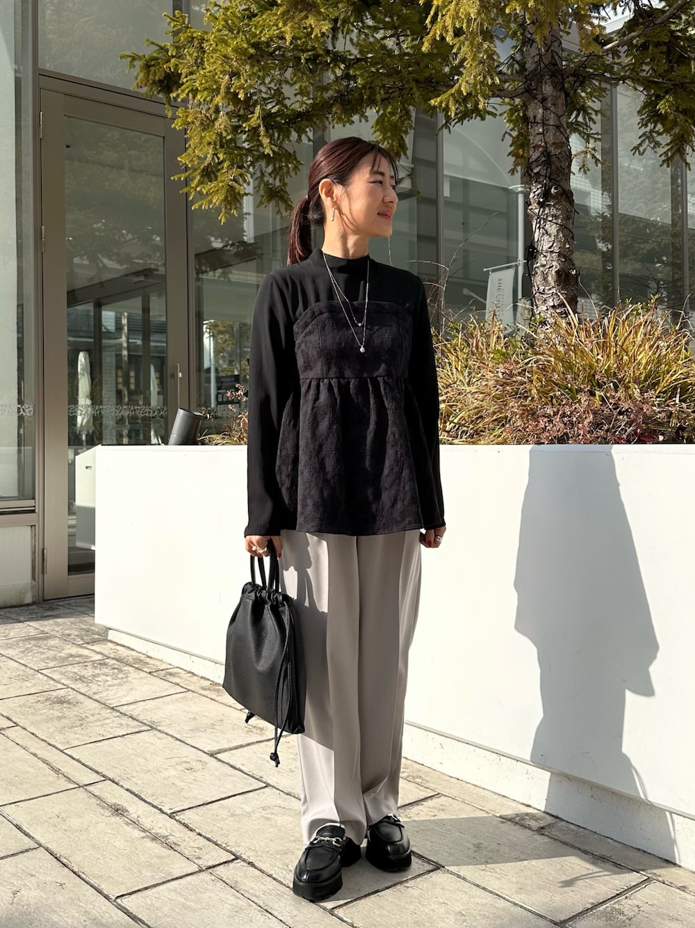 ブラック系のシャツ/ブラウス、ベージュ系のその他パンツ、ブラック系のショルダーバッグを着用したレディースの冬コーディネートの1枚目の写真
