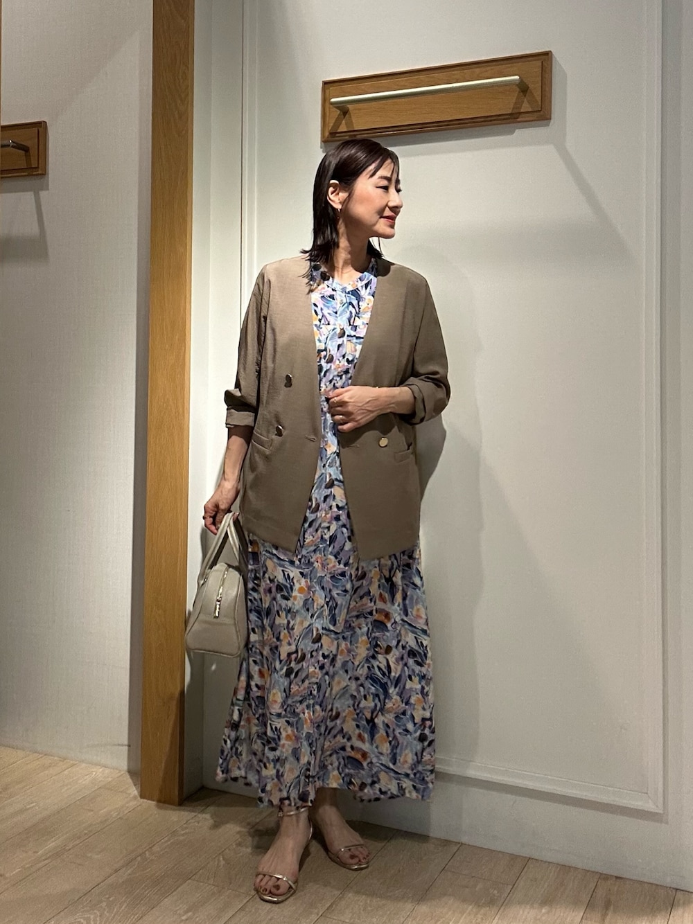 ブルー系のワンピース、イエロー系のノーカラージャケット、ベージュ系のボストンバッグを着用したレディースの夏コーディネートの1枚目の写真