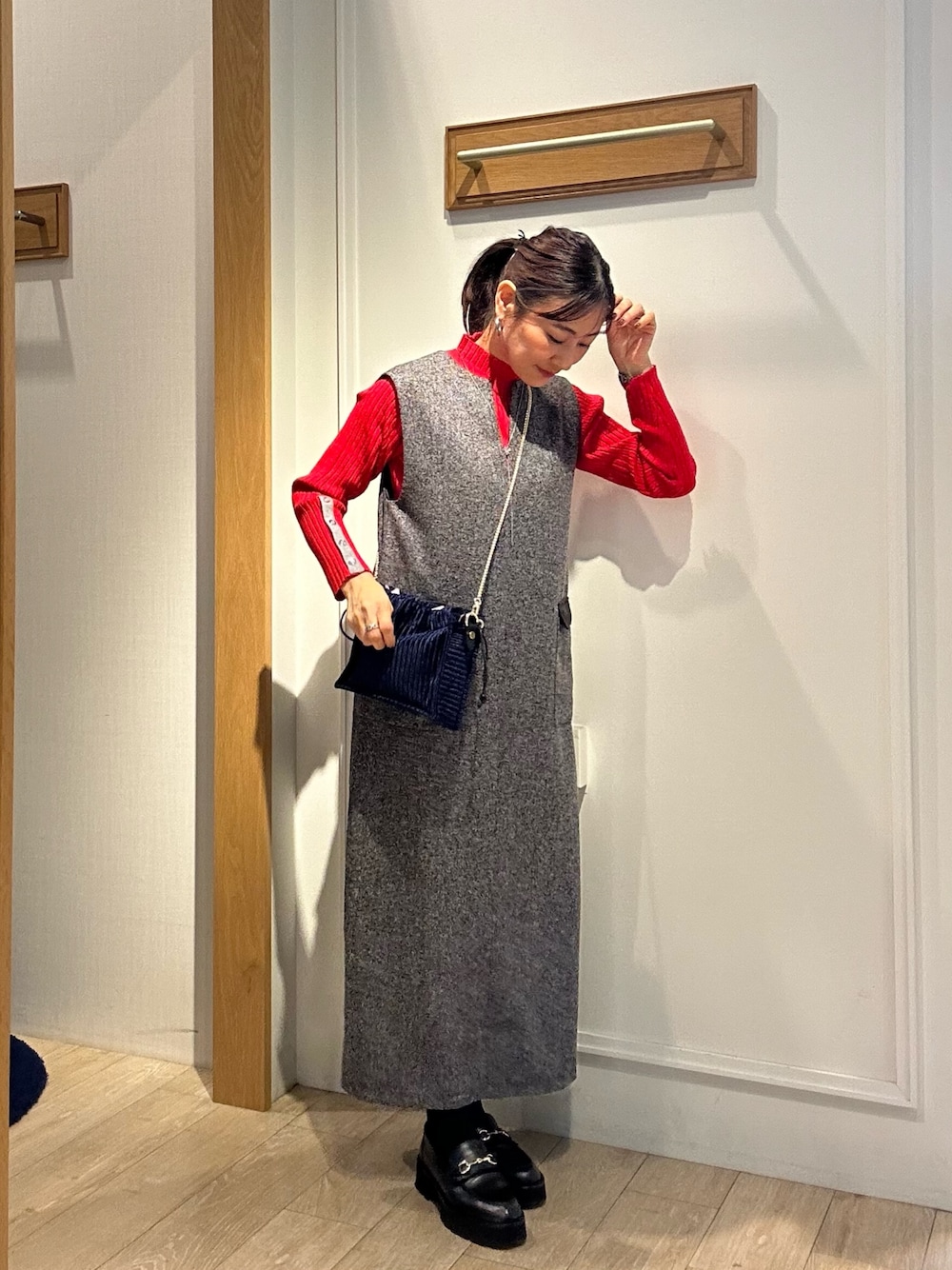 グレー系のワンピース、レッド系のニット/セーターを着用したレディースの秋コーディネートの1枚目の写真