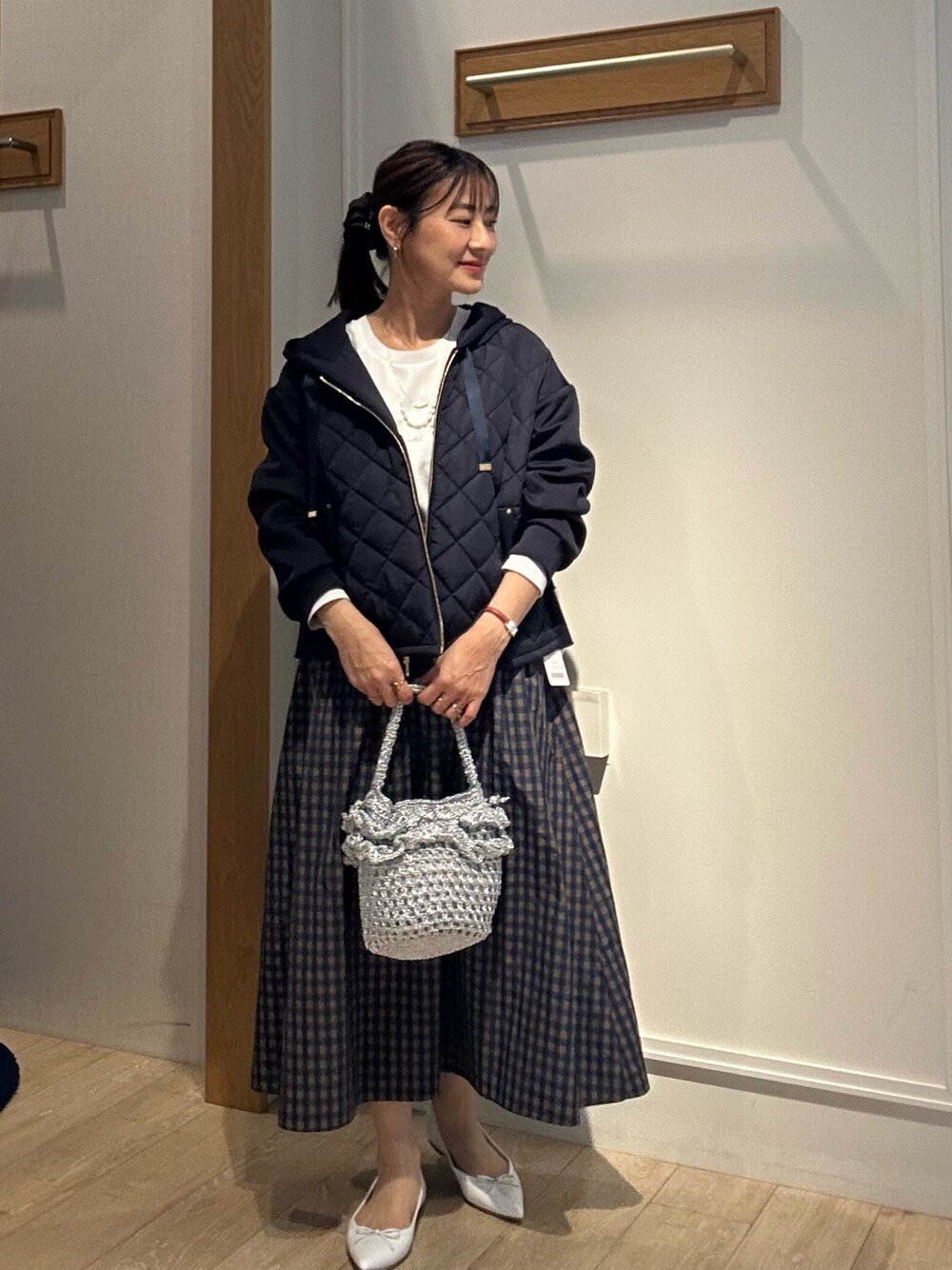 ホワイト系のTシャツ/カットソー、ブルー系のブルゾン、ブラウン系のスカートを着用したレディースの冬コーディネートの1枚目の写真