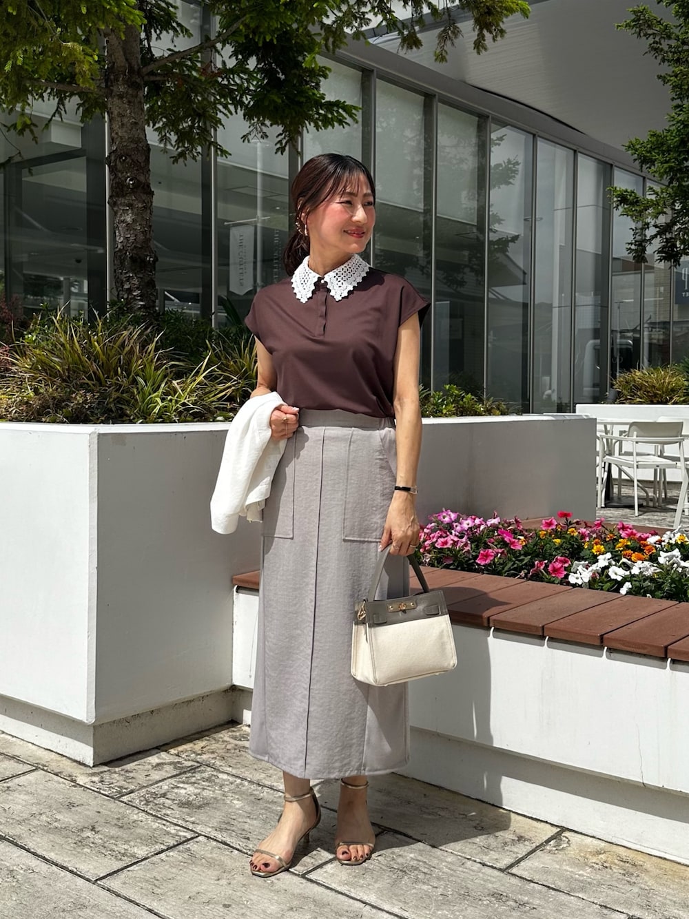ホワイト系のノーカラージャケット、ブラック系のTシャツ/カットソー、グレー系のスカートを着用したレディースの夏コーディネートの1枚目の写真