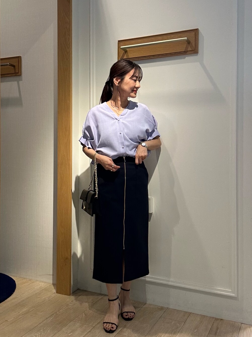 パープル系のシャツ/ブラウス、ブルー系のスカート、ブラック系のショルダーバッグを着用したレディースの春コーディネートの1枚目の写真