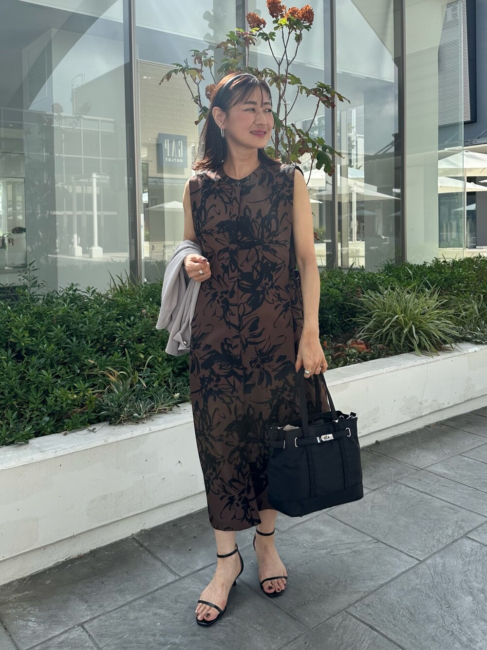 ベージュ系のワンピース、ブラック系のトートバッグ、ベージュ系のノーカラージャケットを着用したレディースの秋コーディネートの1枚目の写真